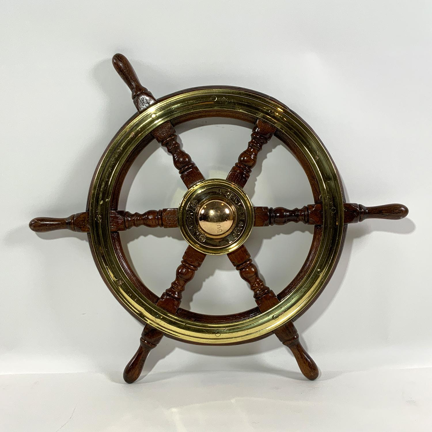 Early twentieth century six spoke ships wheel with turned spindles. Heavy brass hub is engraved 