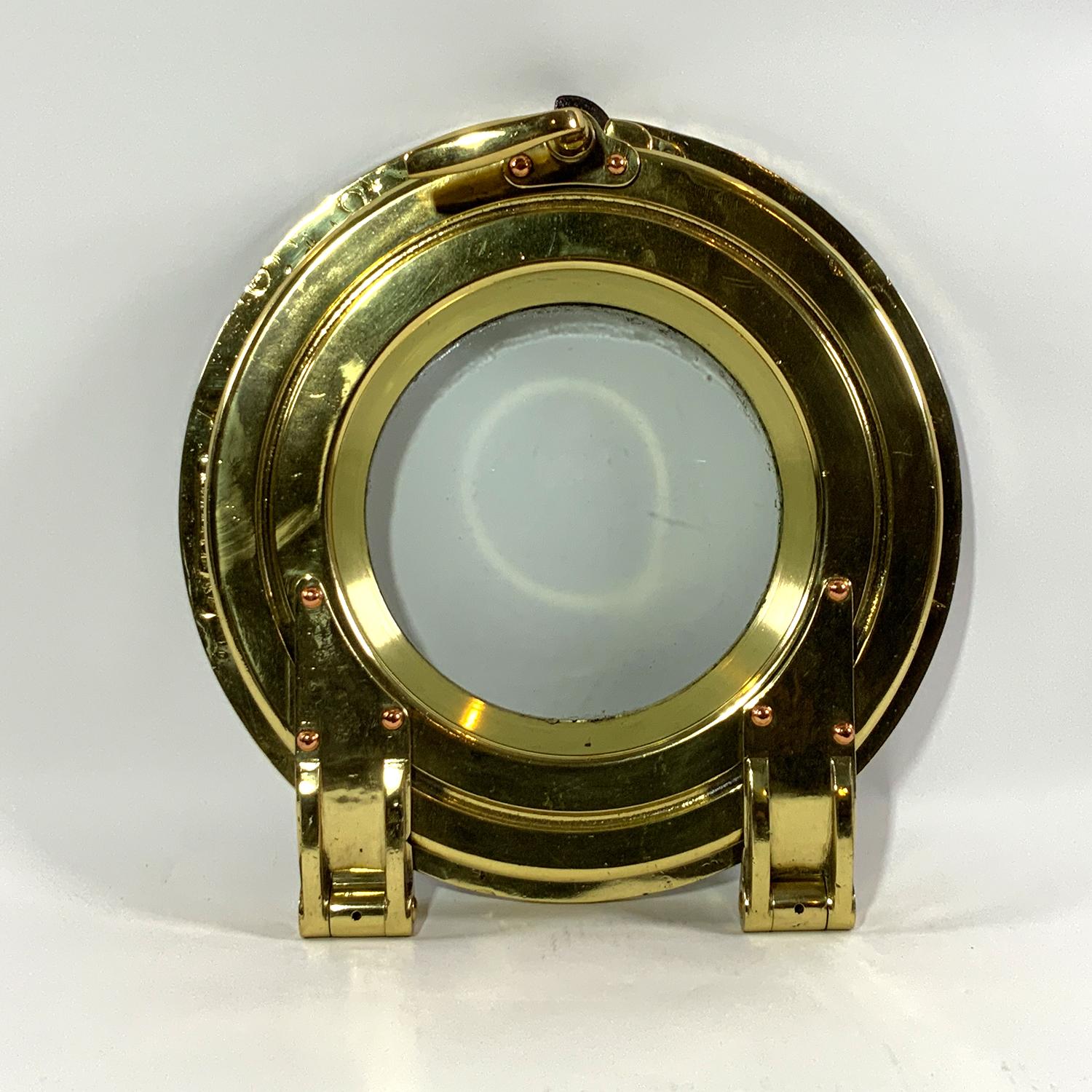 Solid brass hinged door porthole from a very high quality yacht. Superb hinge mechanism. Impossible to reproduce. Circa 1920.