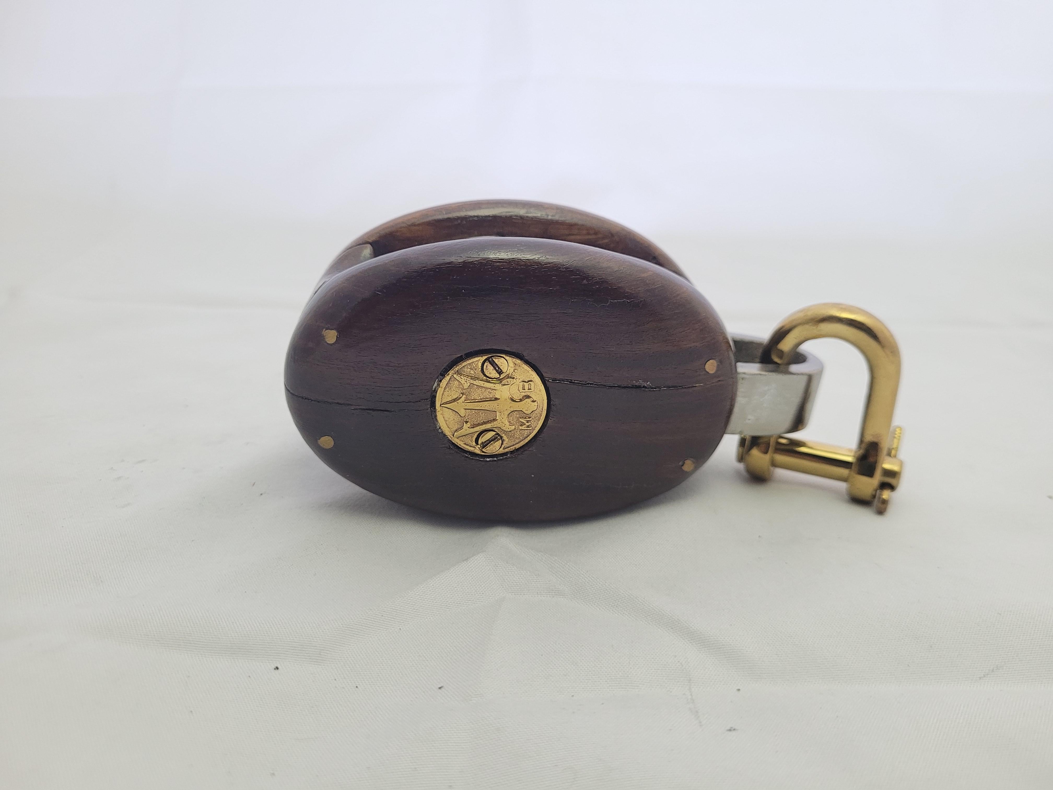 Nautical pulley block by Merriman of Boston. Brass badge with trident and M.B. Hardwood housing is pinned together and holds the polished brass sheave. Awesome restoration. Great Nautical Accent Piece
Weight: 3 lbs.
Overall Dimensions: 6