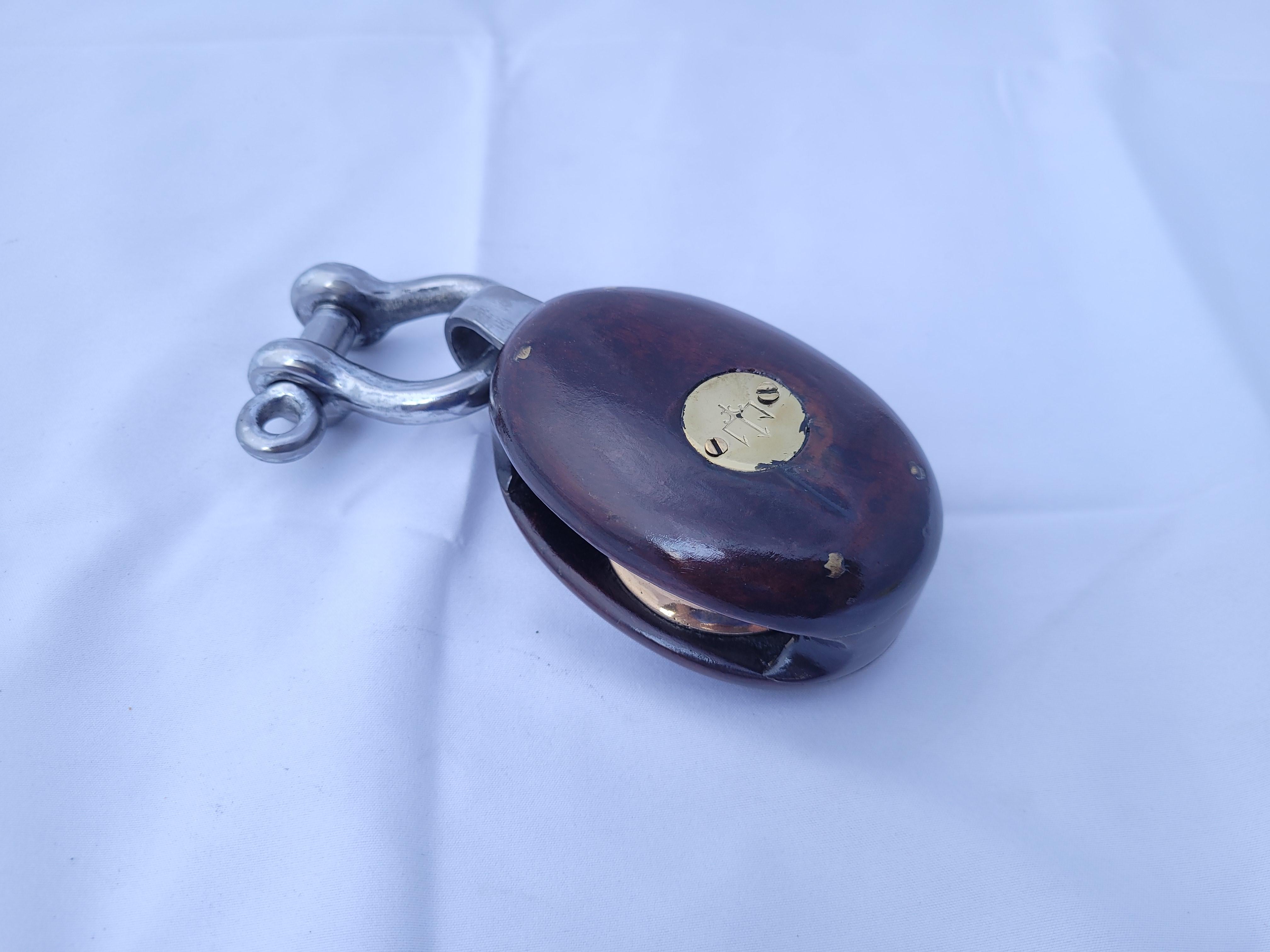 Nautical pulley block by Merriman from the early twentieth century. Brass badges with trident symbols. This relic has been meticulously restored. The rosewood body holds the brass sheave. Polished steel shackle

Weight 2 lbs
Overall Dimensions 2