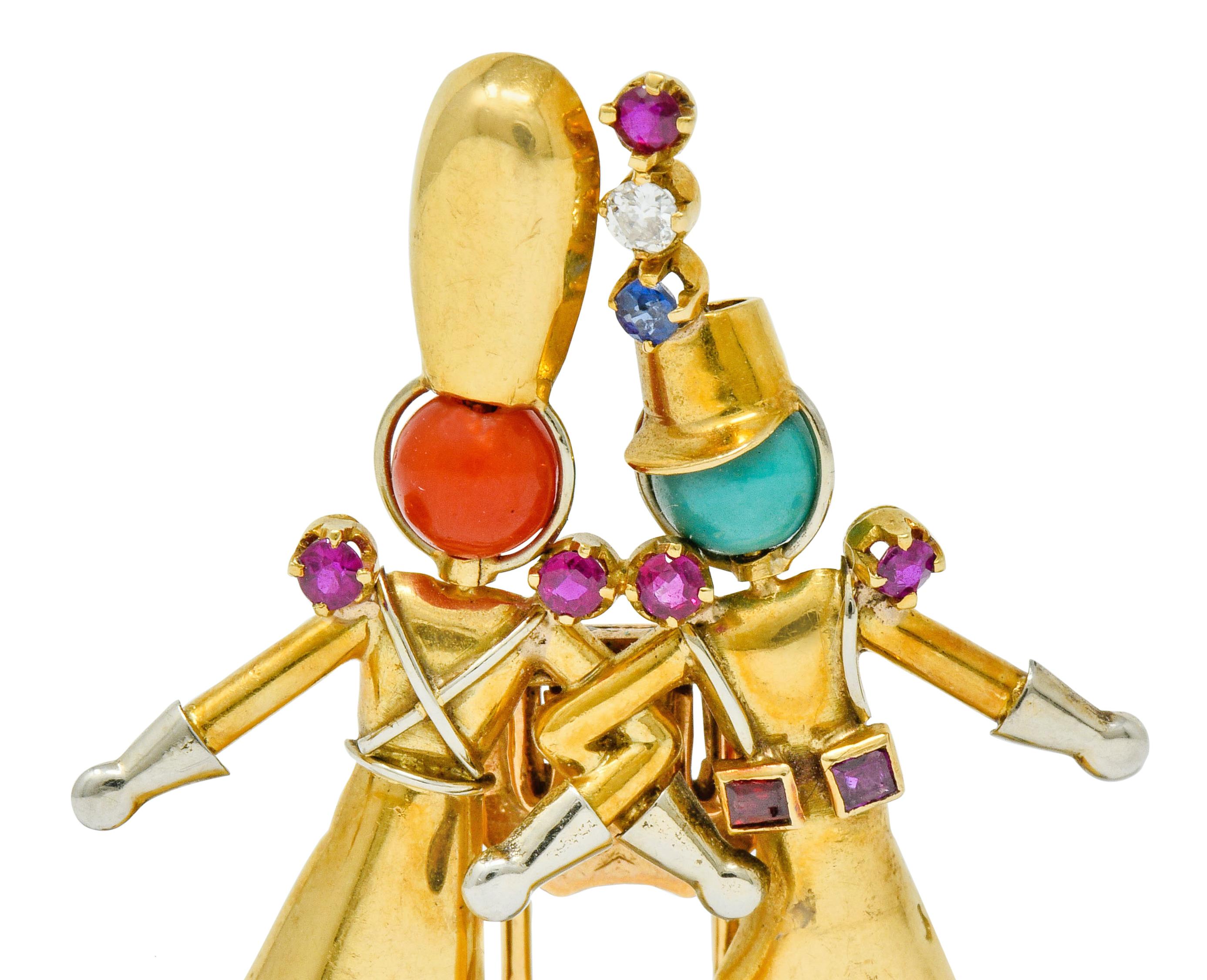 Brooch is designed as two jovial soldiers joined arm in arm dressed in polished gold uniforms with platinum details

Heads and shoes are comprised of round coral and turquoise, opaque and brightly colored with very good polish

Accented by diamond,