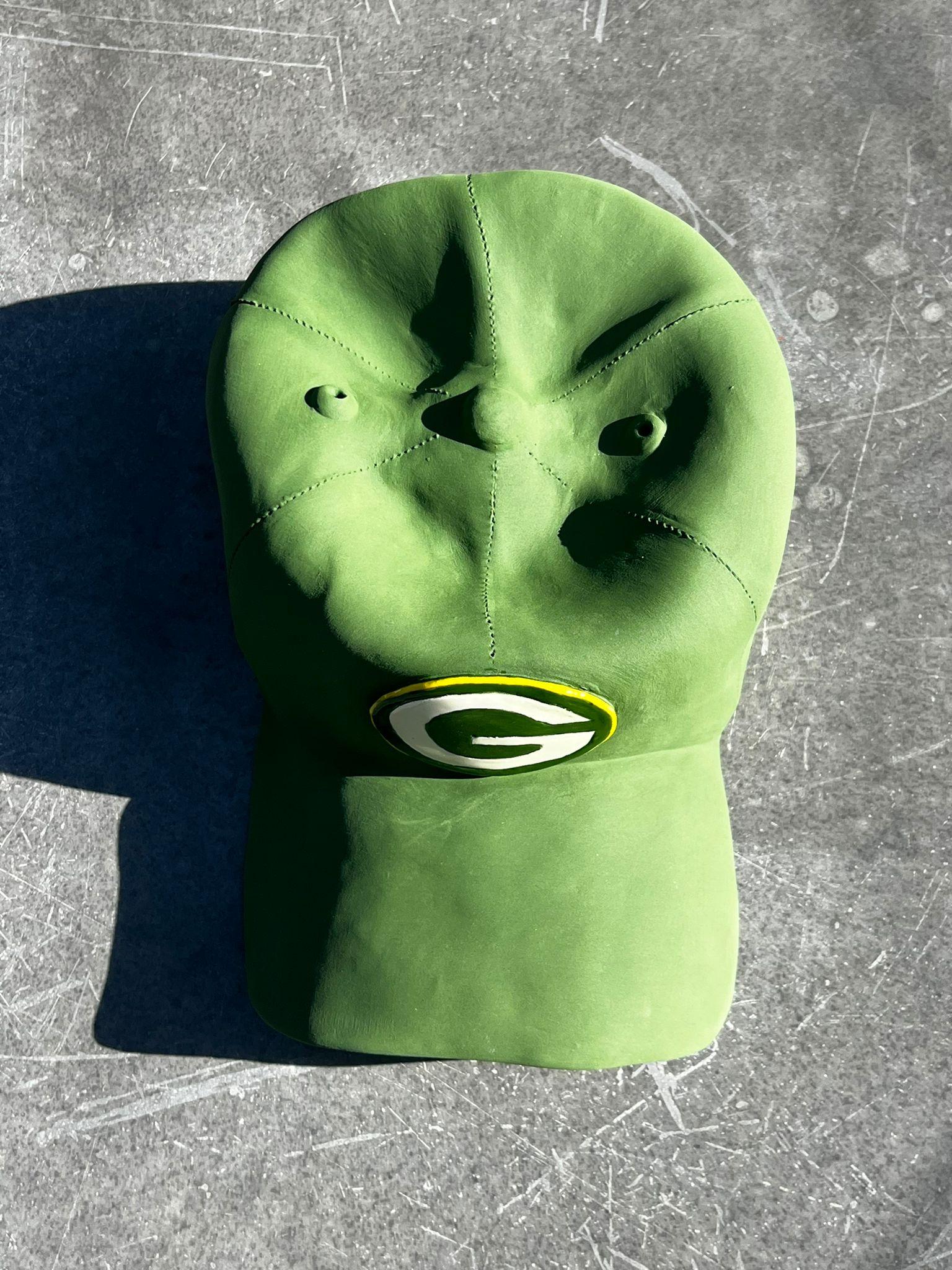 Diese wunderschöne, einzigartige, handgefertigte Keramikmütze der Green Bay Packers stammt aus dem neuesten Werk von Yael Yanay.

Diese handgefertigten Keramikhüte  sind sorgfältig so gestaltet, dass sie ikonischen Baseballkappen ähneln, komplett