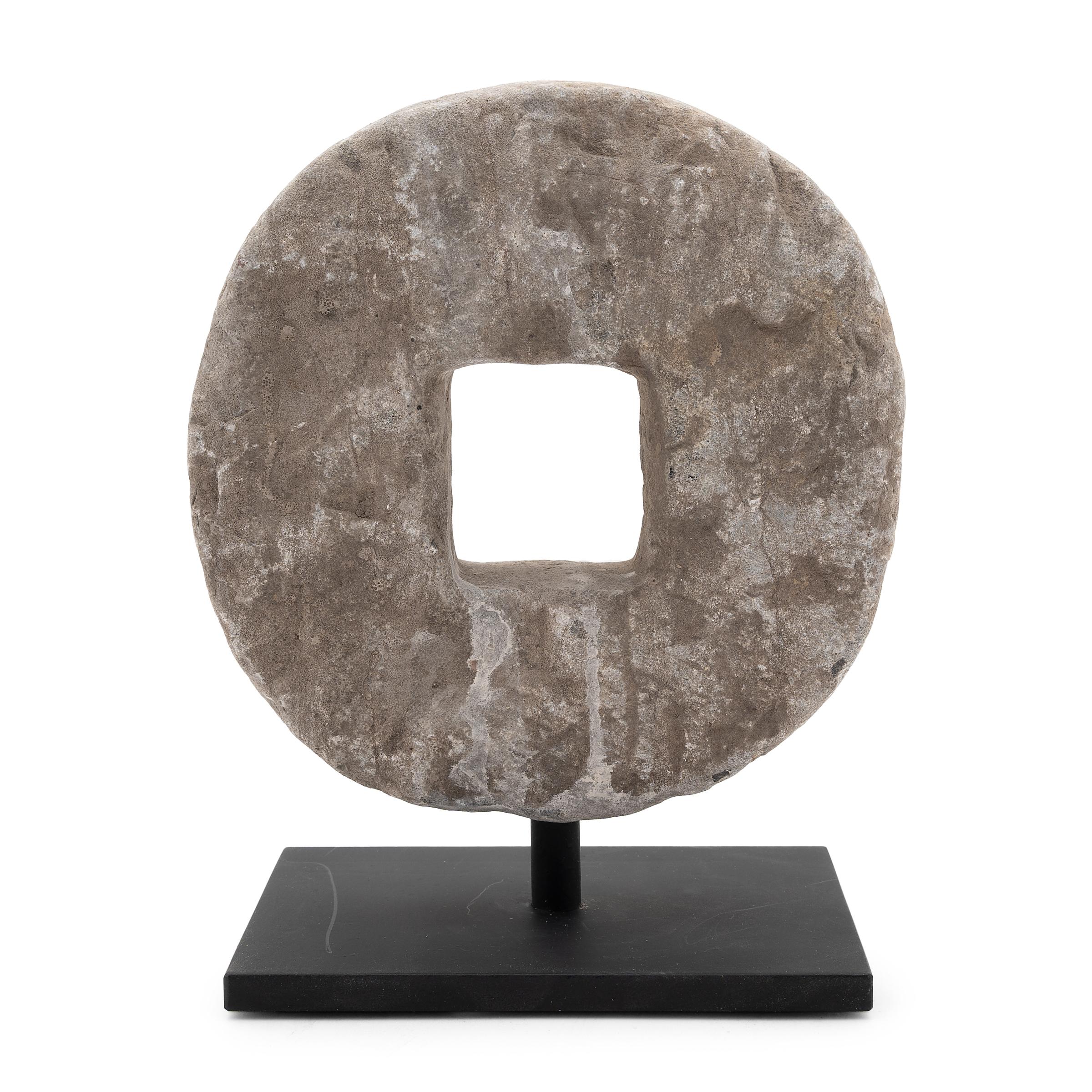 This round stone disc originated as an early 20th-century threshing wheel. Secured to a wooden axel that ran through the center, the stone was rolled across stalks of wheat to separate the grain, pulled either by man or by ox. With simplicity of
