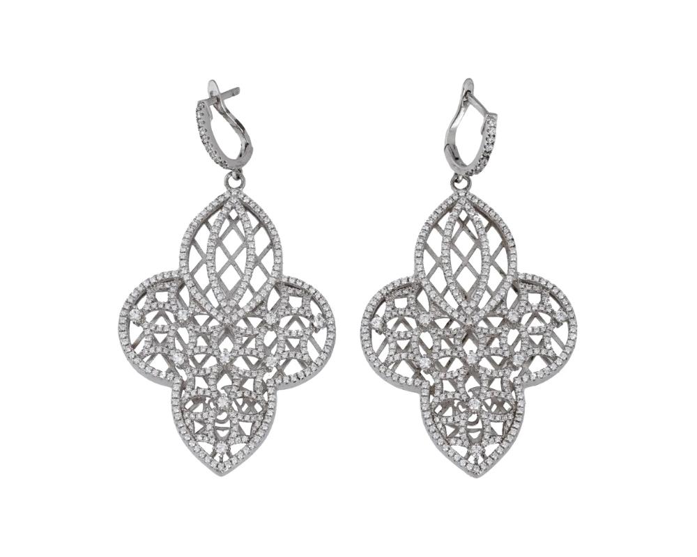 A pair of vintage sterling silver dangle earrings by Yagi Designs Inc., an American costume jewelry brand. Ornamented quatrefoil shape. The earrings are richly garnished with German simulated diamonds. Plug backing, marked Jagi, 925. Total Weight: