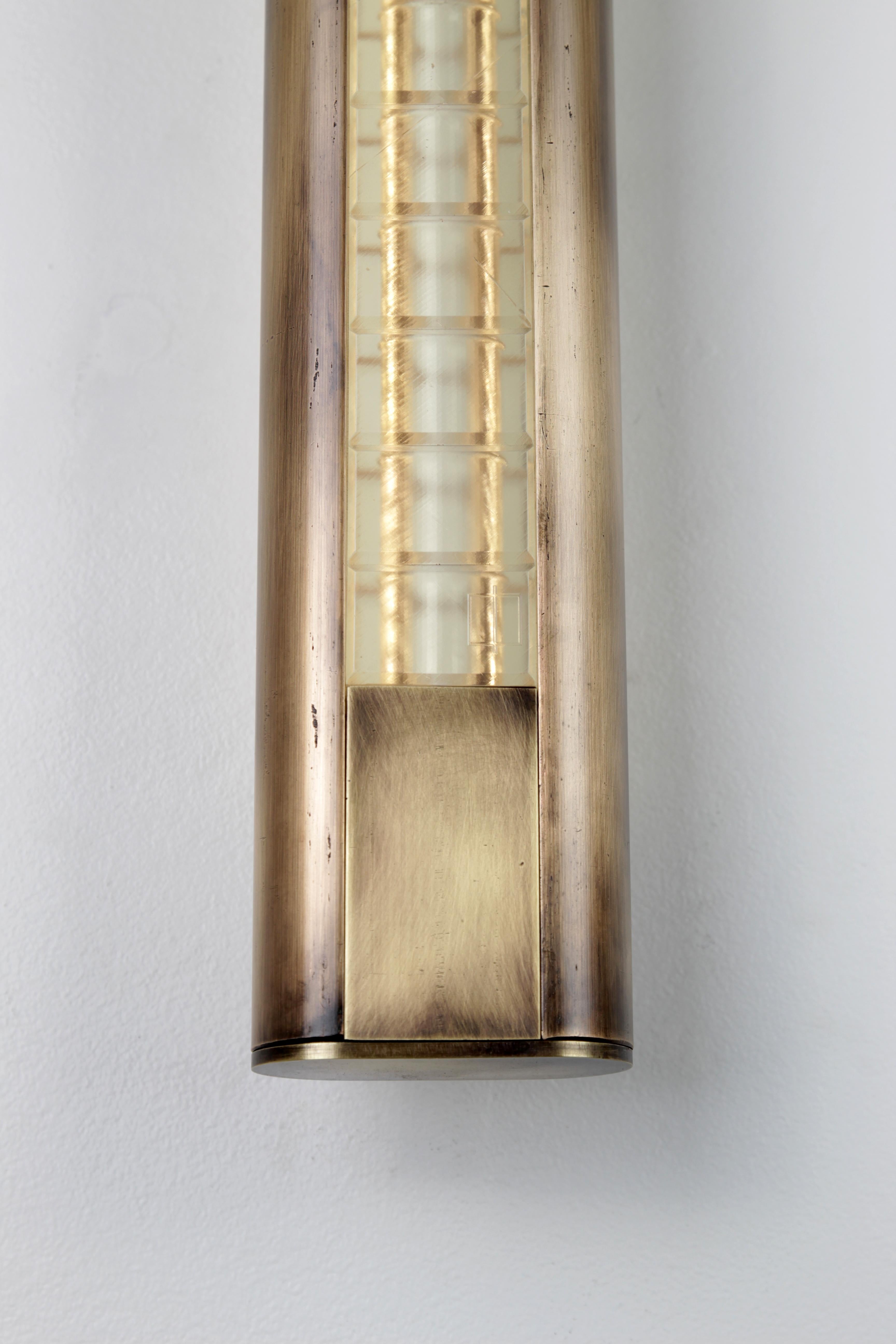 Solid brass half moons cradle repeating rectangular lenses adorned with bevels on every edge. Front and back illumination. Sconce can be mounted facing up or down. 

Finish: Aged brass
Lens: Natural

12v DC LED 
Dimmable 
3800K color 
High CRI/RA