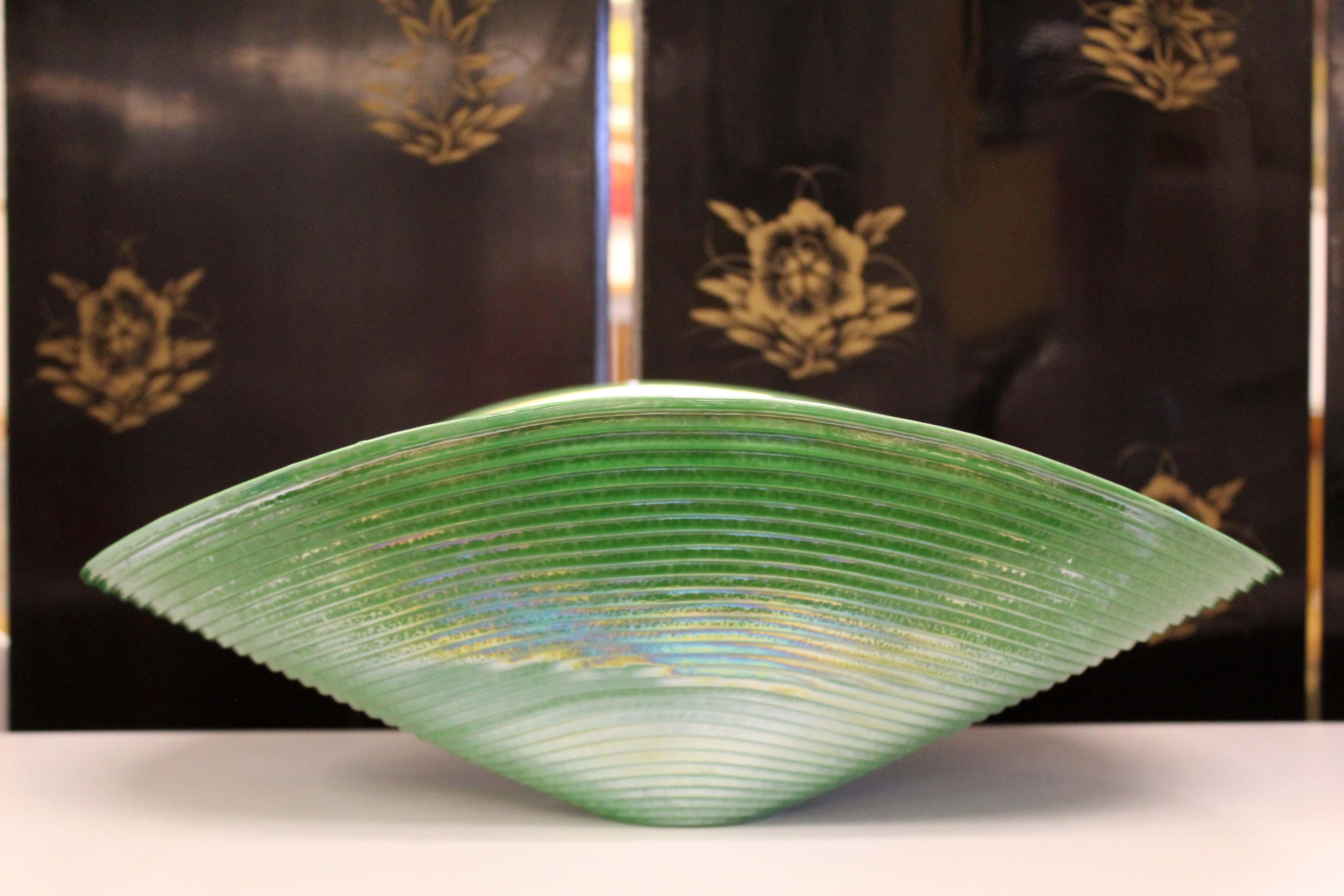 Lovely as an artful centerpiece, this green, iridescent bowl is stamped Yalos Casa Murano on the bottom. Yalos Murano represents the fusion of tradition and innovation in the artistic production of Murano glass intended for the modern environment.
 