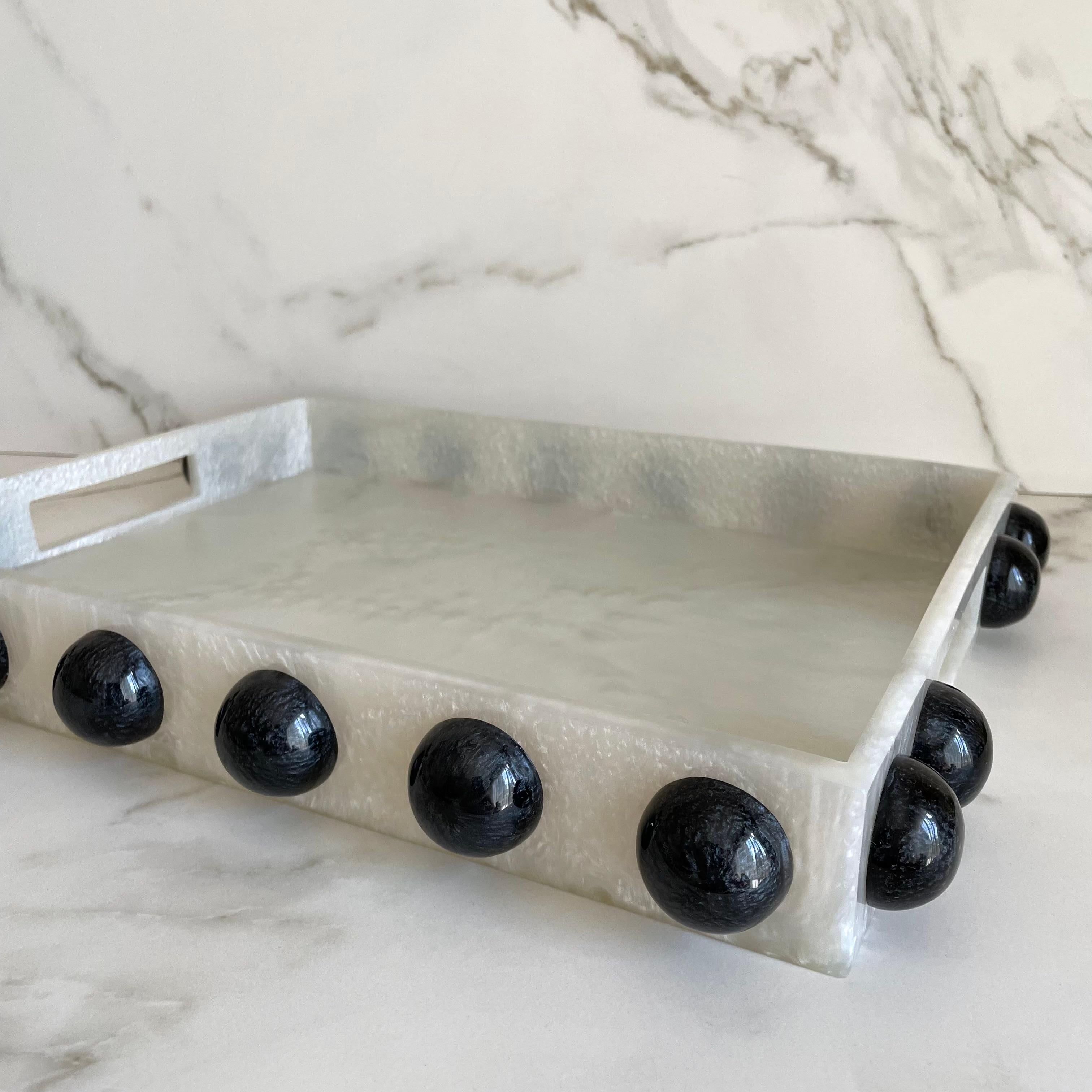 Our rectangle tray has clean lines, polished finish and is embellished with semi spheres that make it one-of-a-kind. This modern tray is just the thing for serving breakfast in bed, cocktails on the patio or just as a statement piece in any