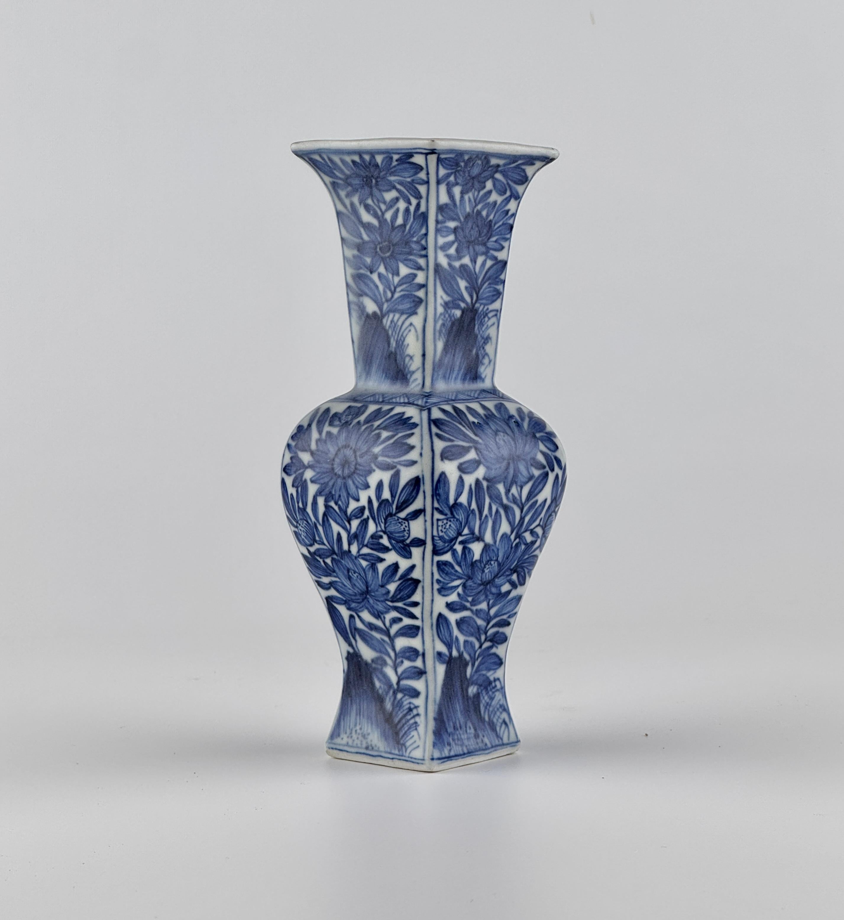 Each side pencil-painted with stylized chrysanthemum, lotus or daisy sprays issuing from rockwork. This blue and white square vase with rounded sides has a flaring mouth and a long neck. This shape can be traced back to Chinese bronzes. It is
