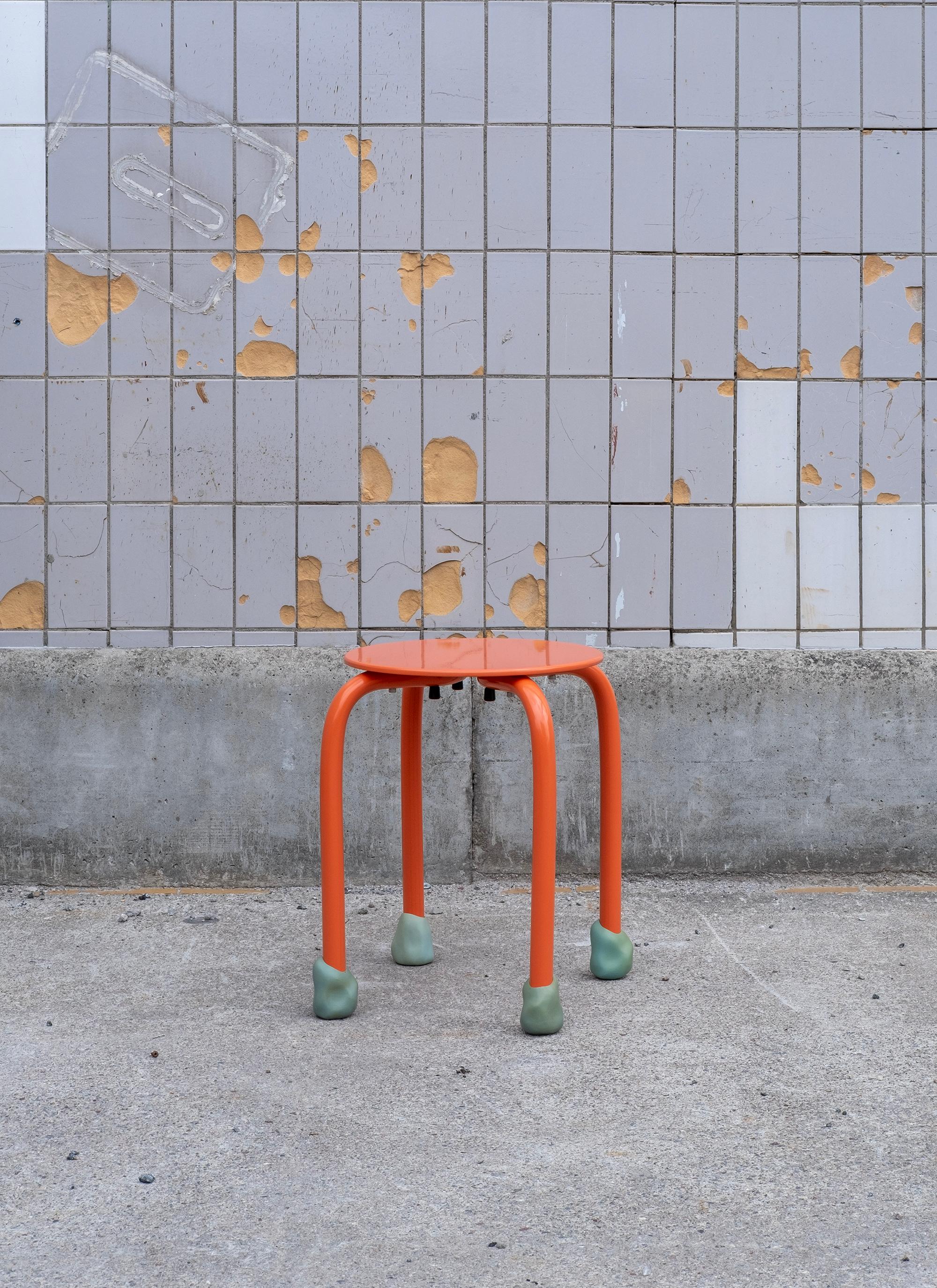 Der Yareta Aluminiumhocker in Orange mit blauen Gummifüßen, entworfen von Erik Olovsson, ist eine lebendige Verschmelzung von skulpturaler Verspieltheit und industrieller Präzision. Der Hocker verfügt über eine solide, 8 mm dicke Aluminiumplatte,
