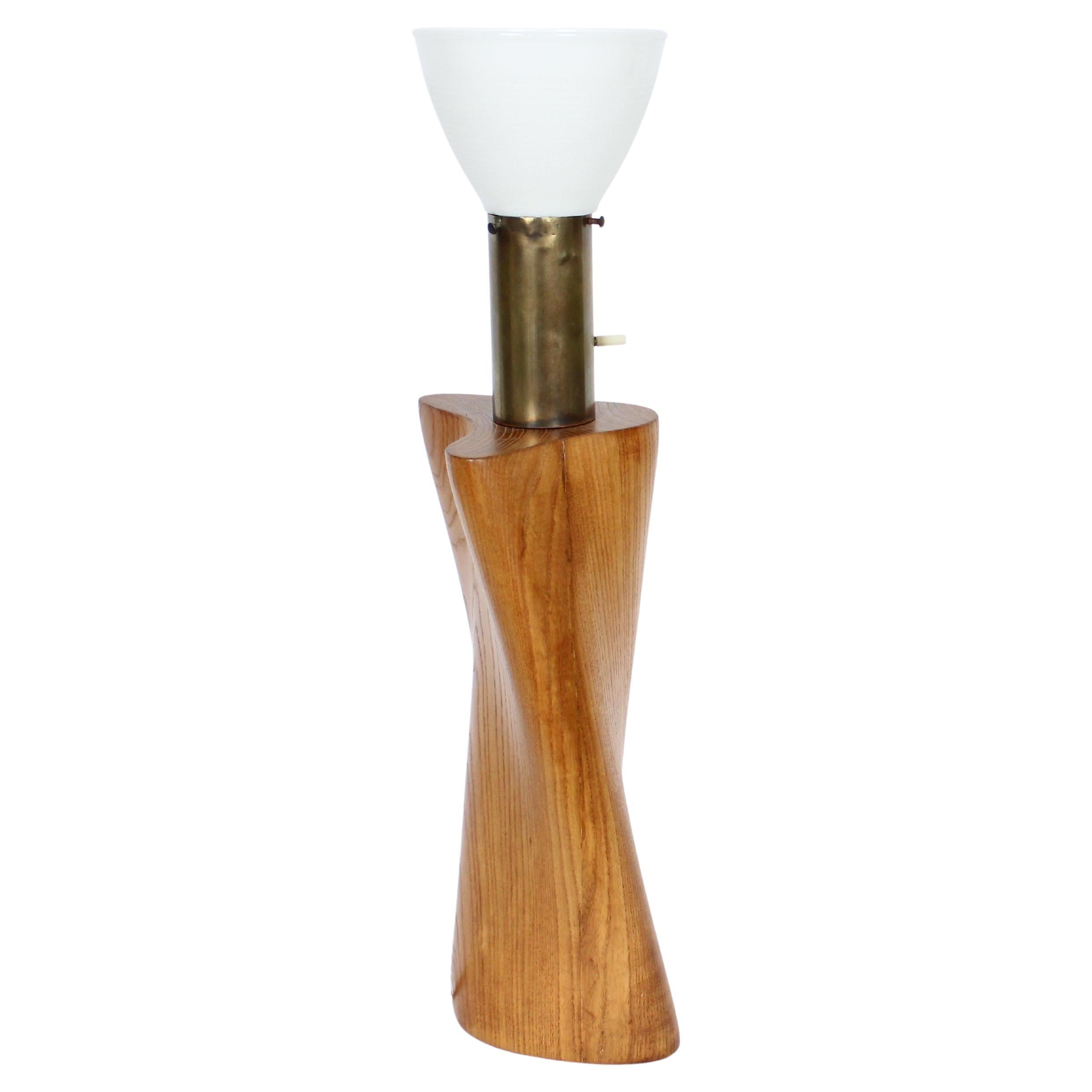 Early Organic Modern Yasha Heifetz solid Ash, Brass 
Glass Table Lamp. Featuring a handcrafted solid smooth sculpted ash biomorphic form with wide cylindrical brass neck and white milk glass liner shade. 21H to top of socket. 16H to top of