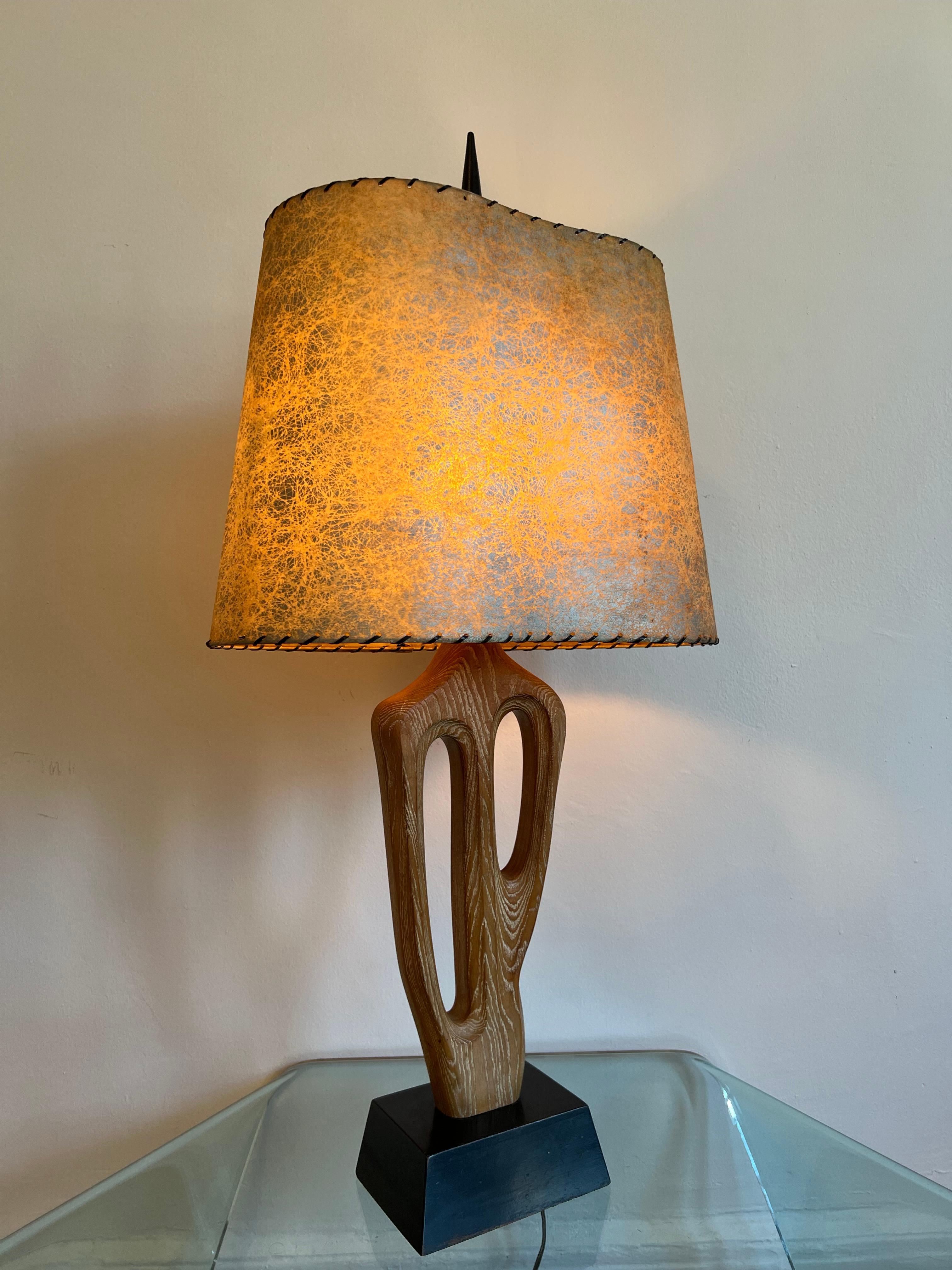 Yasha Heifetz entwarf eine Lampe für das Unternehmen Heifetz Lighting Co., das sie selbst herstellt. 

Eine hohe, skulpturale, biomorphe Tischlampe aus kerosiertem Eichenholz auf einem schwarz lackierten Holzsockel. 

Aus einem einzigen Stück Eiche