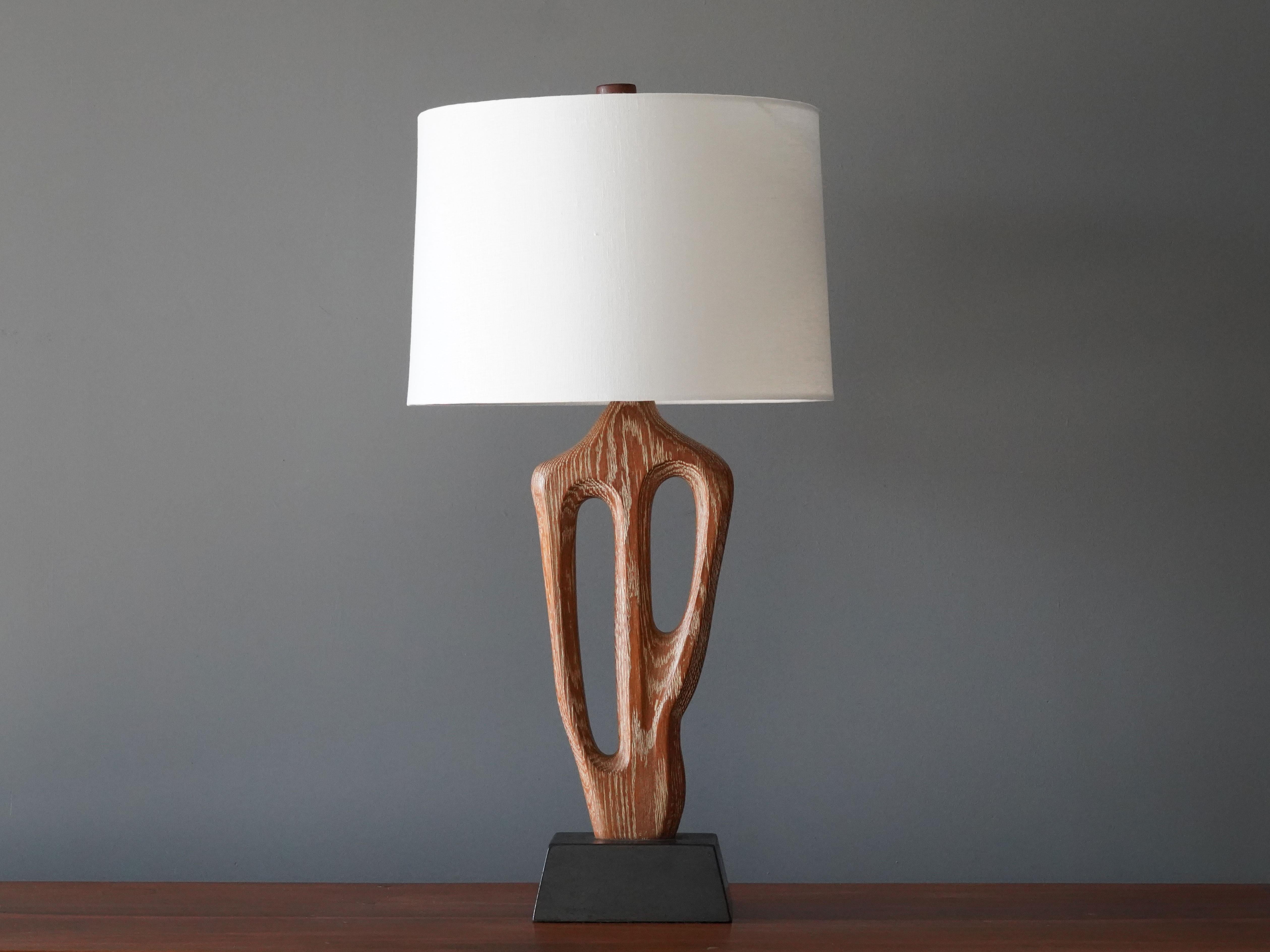 A rare organic / biomorphic table / desk lamp. Designed and produced by Yasha Heifetz, America, 1950s. Features a sculptural rod in perused oak on a black-painted wooden base. Signed on the base. Sold without lampshade. 

Other designers of the