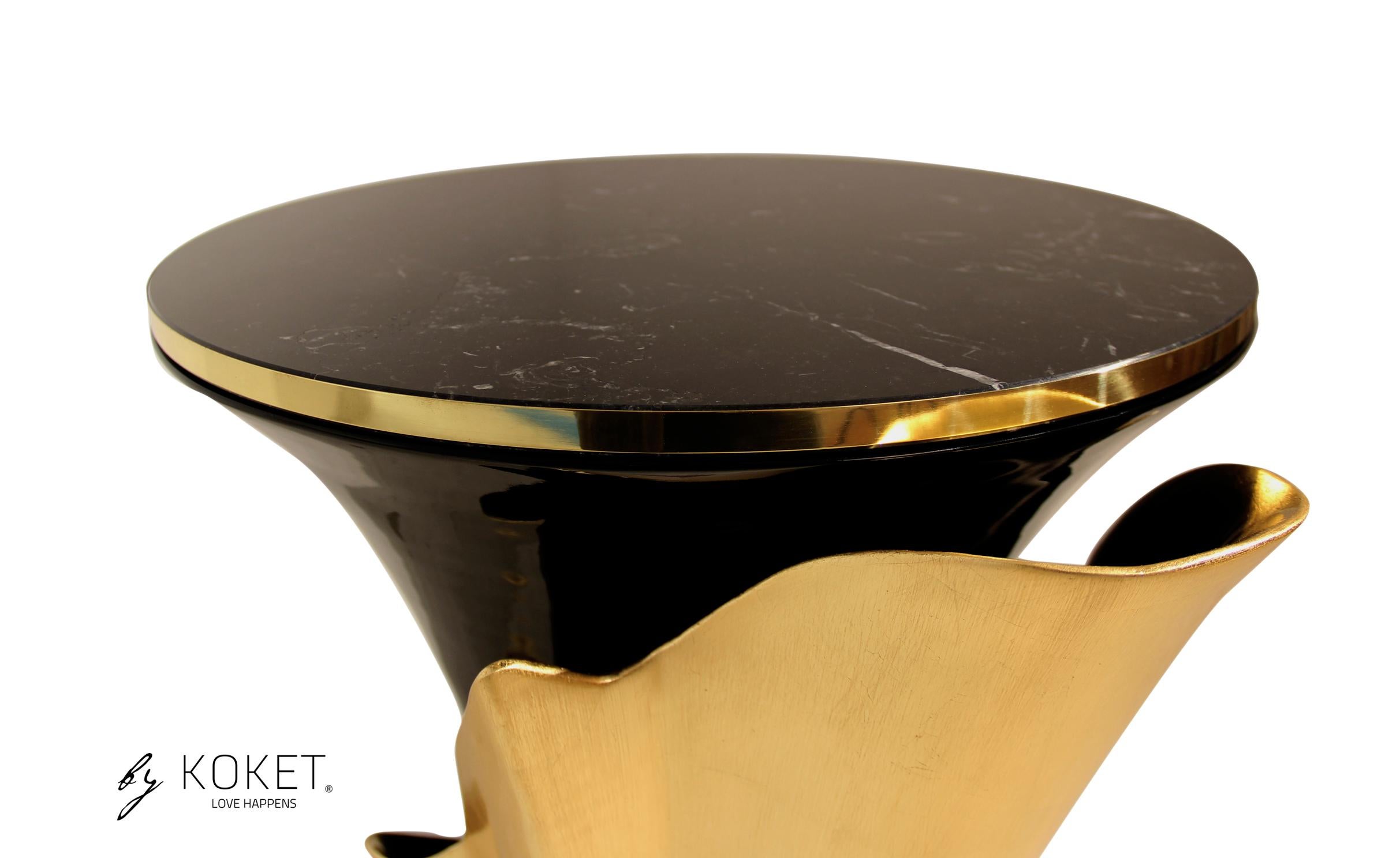 A central piece to any space, the contemporary design of the Yasmine table will have everyone doing double takes. The sultry silhouette is fashioned from tailored glass and mounted on a solid wooden base. Classic lacquer and luxurious plated