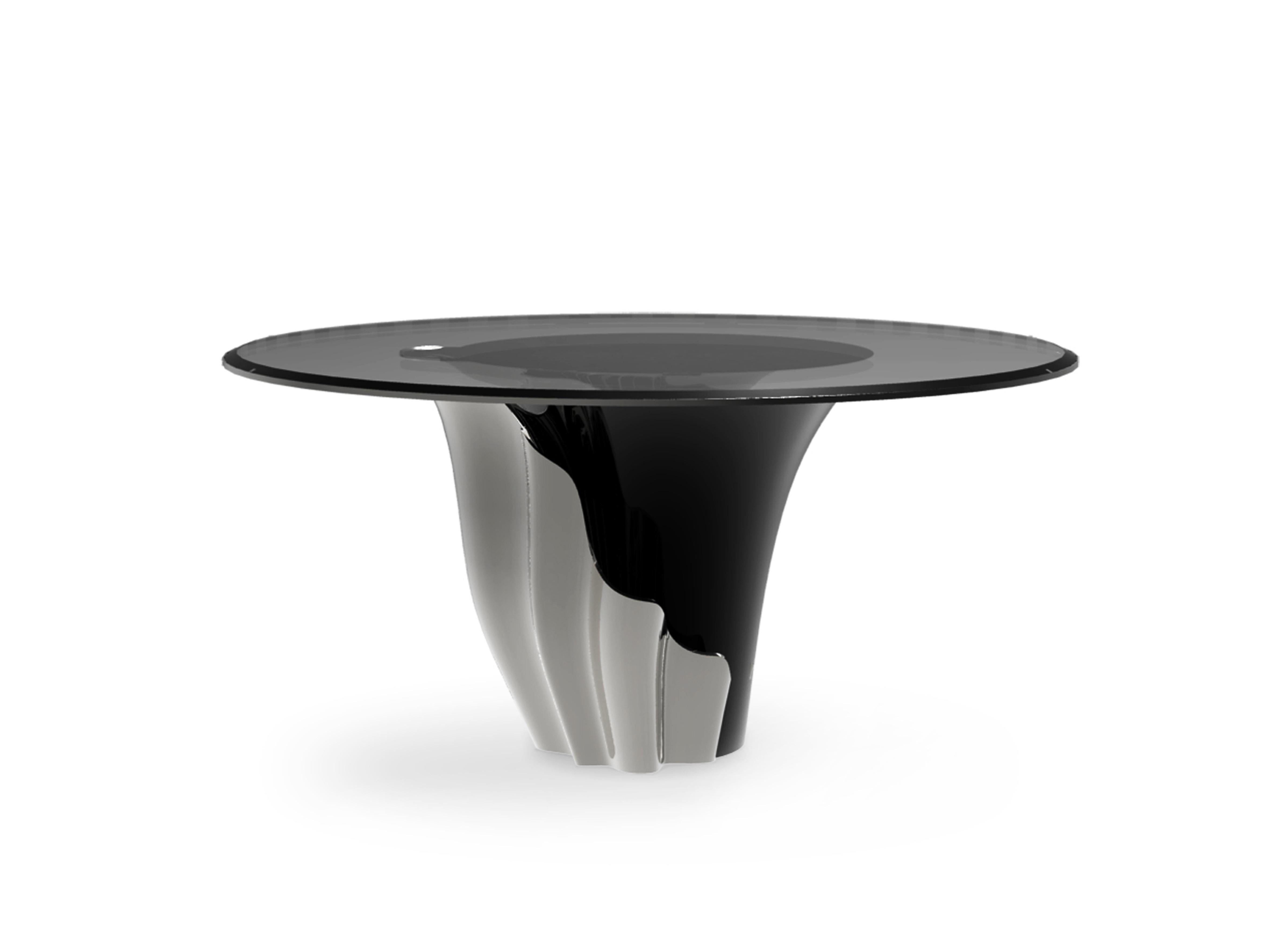 A central piece to any space, the contemporary design of the Yasmine table will have everyone doing double takes. The sultry silhouette is fashioned from tailored glass and mounted on a solid wooden base. Classic lacquer and luxurious plated