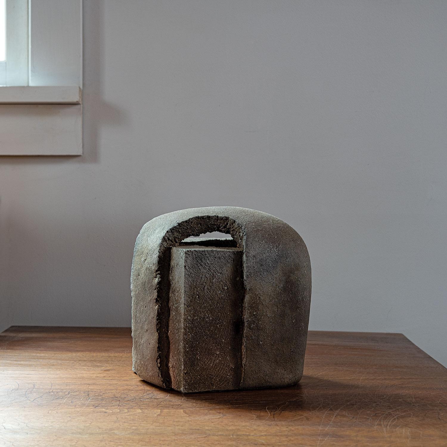 Yasuhisa Kohyama shapes his asymmetrical forms using piano wire, creating distinctive rough surfaces. The clay with its feldspar nuggets creates a tactile quality rarely seen in contemporary work. No glaze is used, but the wood ash and placement in