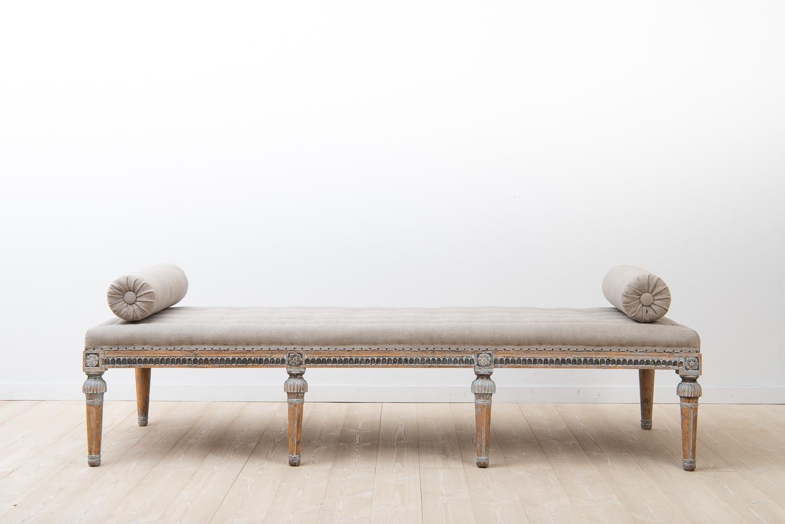 Swedish bench in Gustavian style manufactured around year 1800. The surface is dry scraped to traces of the original paint. The seat is renovated with handmade padding in natural materials, done according to old traditions. It has also been