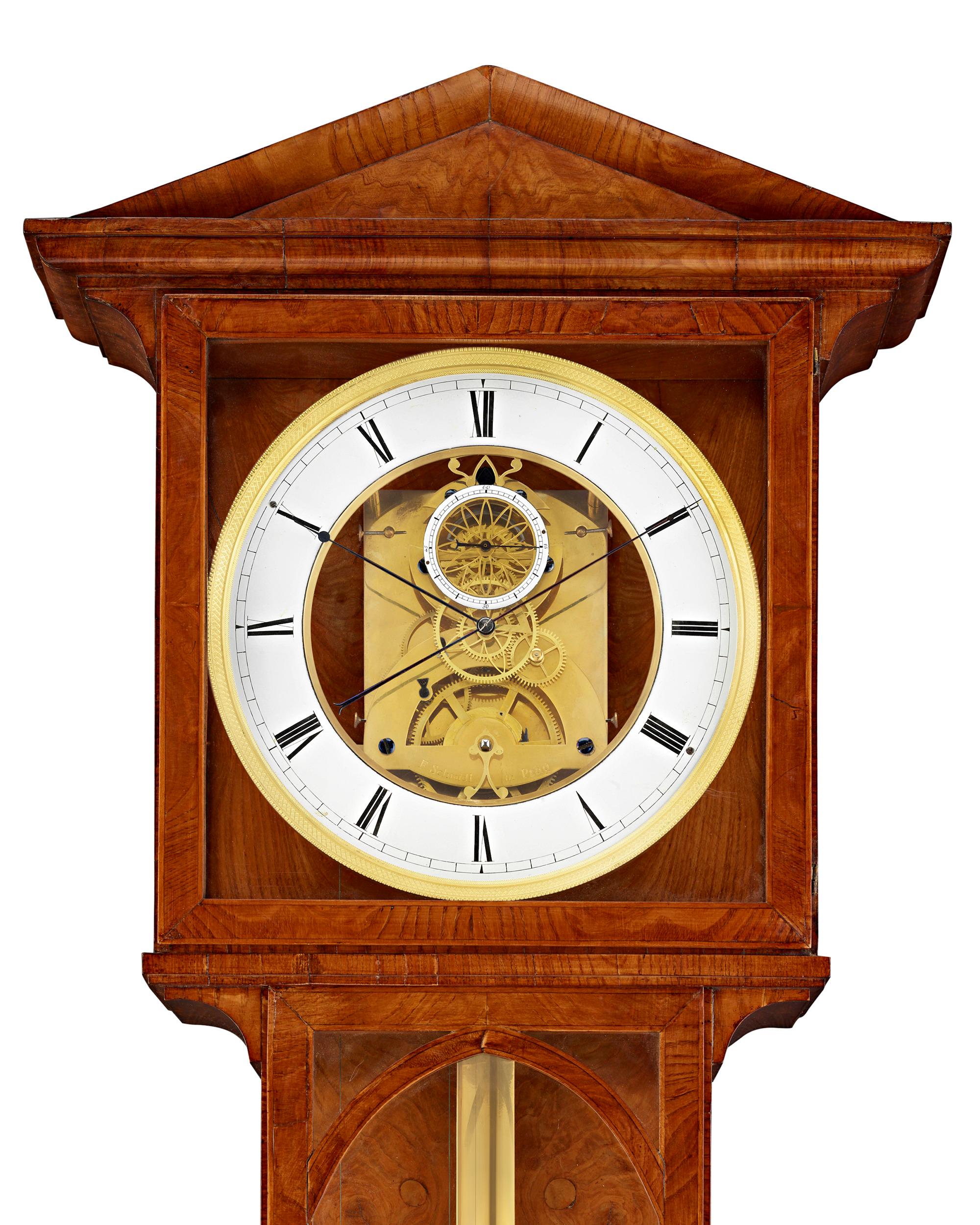 This rare year-going regulator clock, or Laterndluhr, beautifully demonstrates the heights of precision clockmaking. The ash-veneered Biedermeier case houses a weight-driven precision mechanism, as well as a skeletonized center dial that allows one