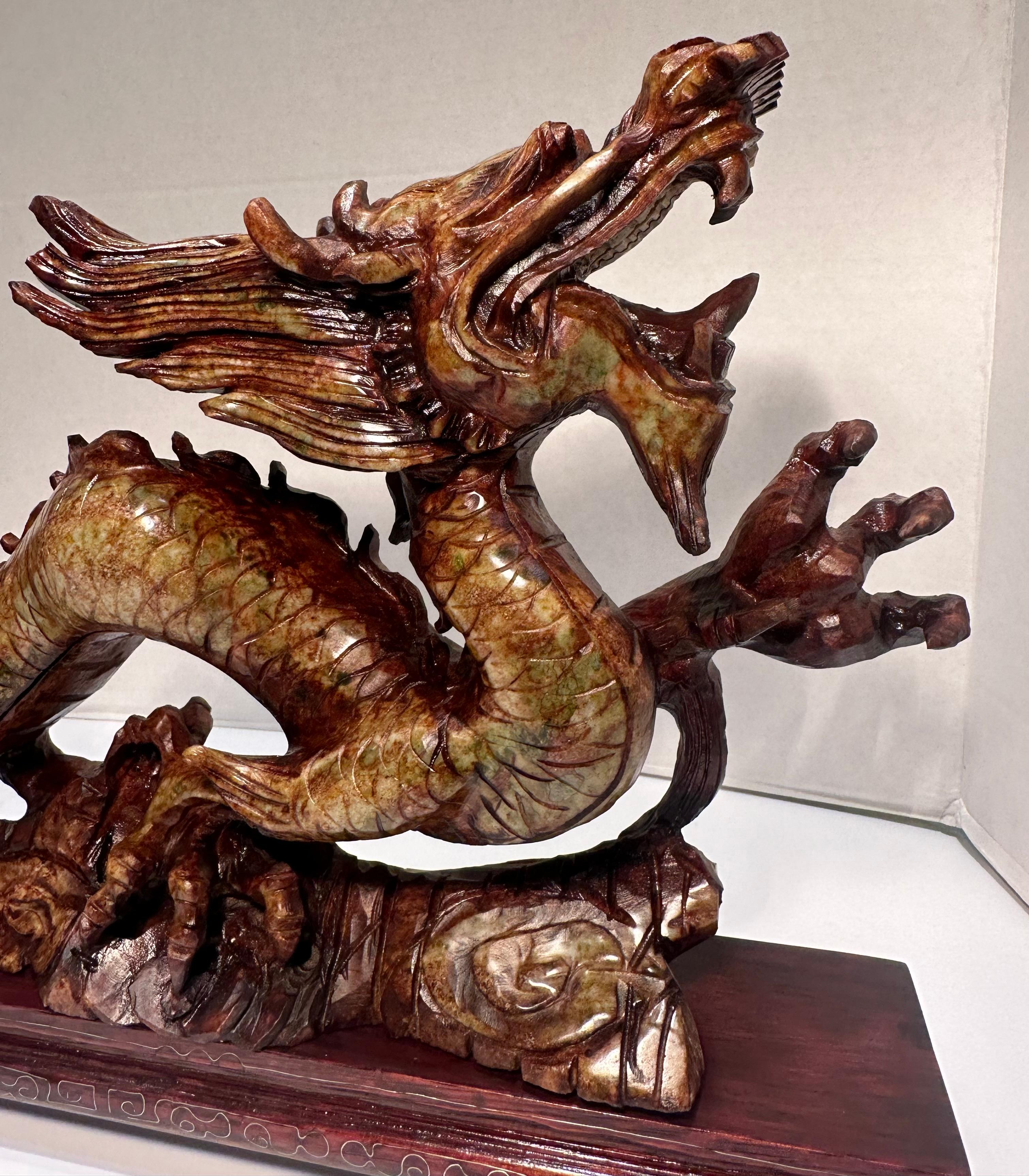 Intricately hand carved from a single block of richly variegated stone, this incredibly detailed and elaborate, Chinese sculpture is a true work of art. It features a dragon on a carved cloud like base and is very meticulously crafted, from the