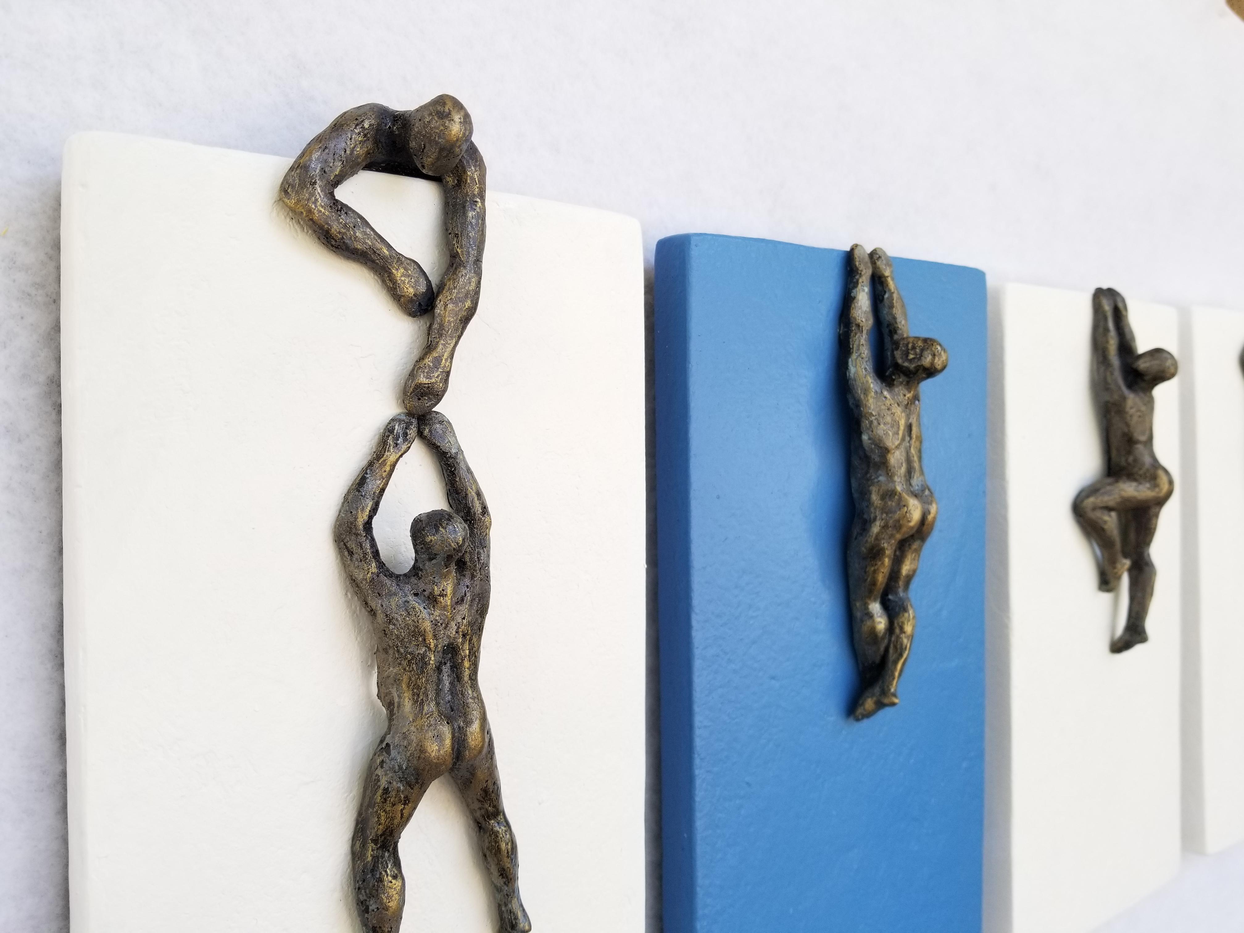 <p>Artist Comments<br>Artist Yelitza Diaz displays a modern piece of climbing figures in four minimalist panels painted in flat shades of white and blue. She paints the bronze beings dangling from the ledges, fighting their way up. Yelitza seeks to