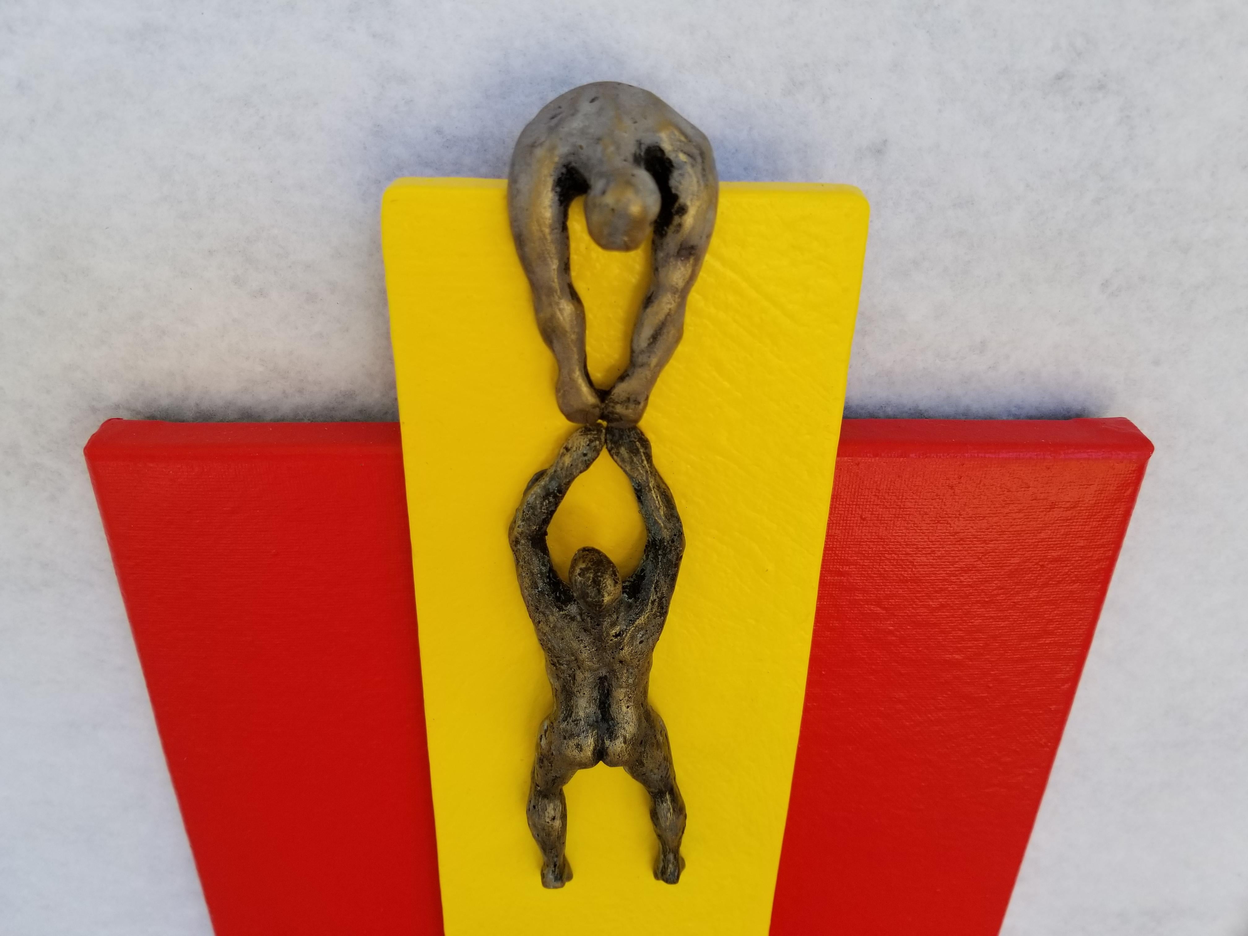 <p>Artist Comments<br>While preserving her aesthetic, artist Yelitza Diaz blends the minimalist with the modern. She displays a metallic figure dangling in the hands of another. She uses bold shades of red and yellow to color the structural