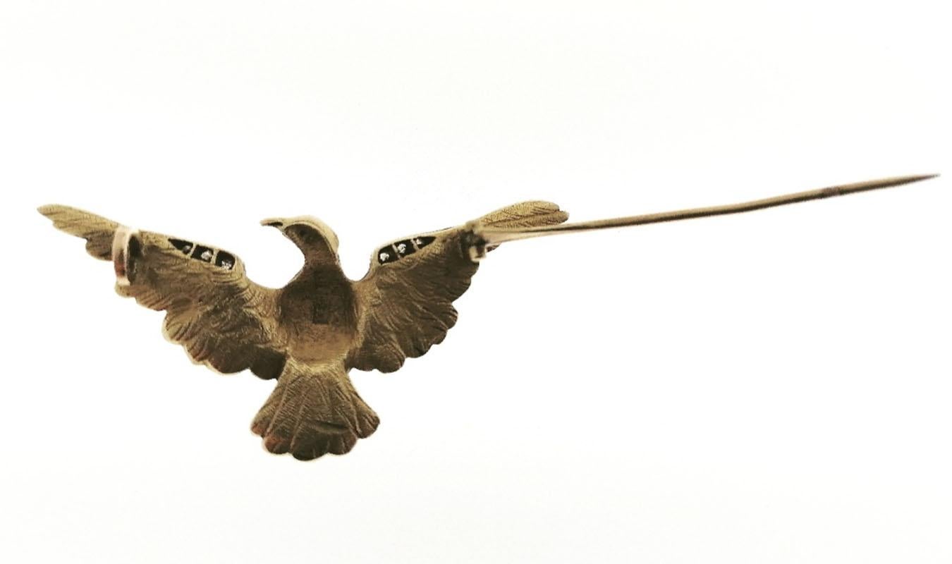 18k yellow gold eagle brooch. It has diamonds on the wings and a 0.15 carat old cut diamond on the legs. Gold marks. With ruby eye.