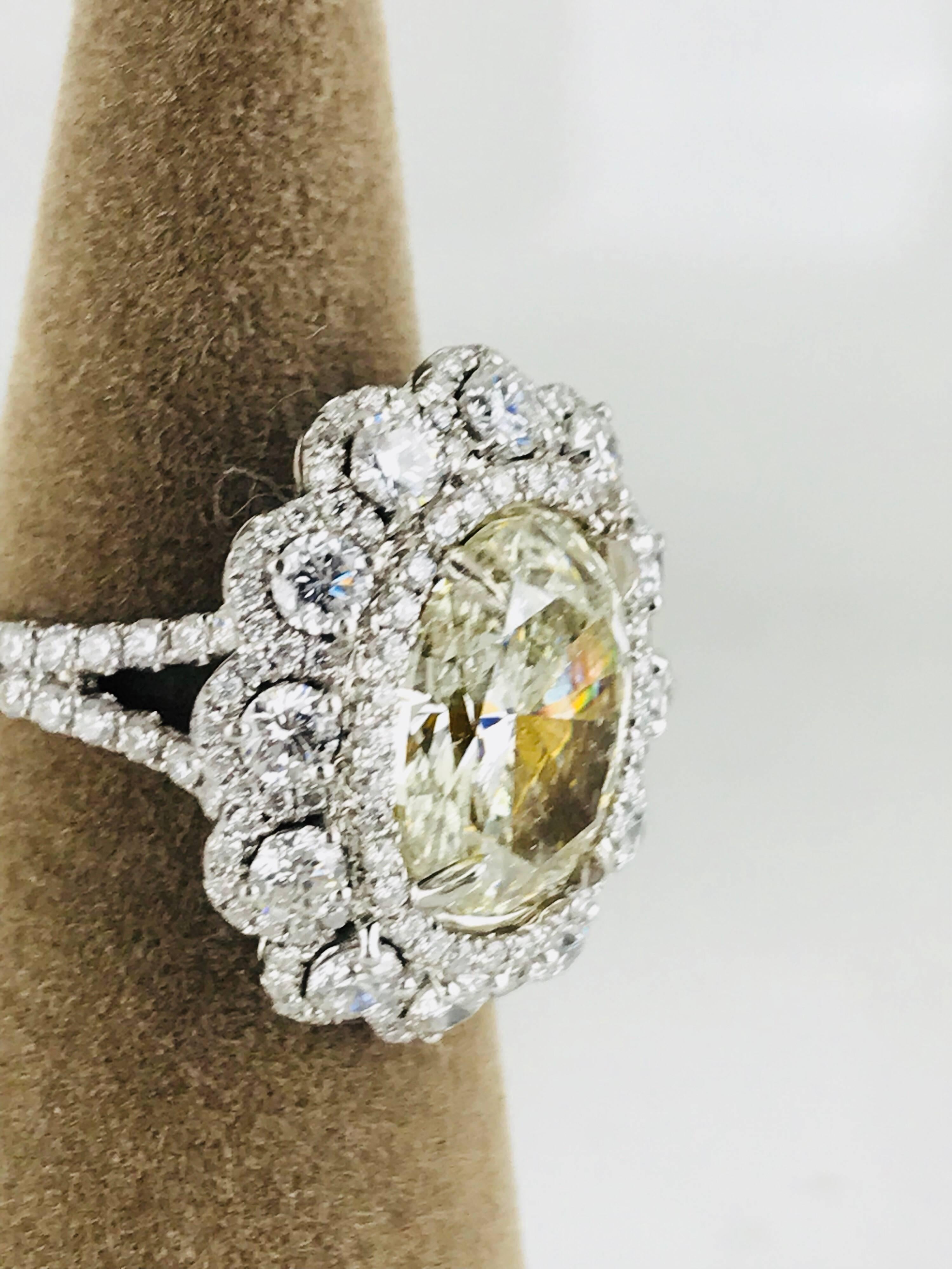 Contemporary ring consisting of a 5.21 carat oval shaped yellow diamond  center, set in a beautiful halo setting.  
 The yellow color of this diamond  is of a GIA color range 