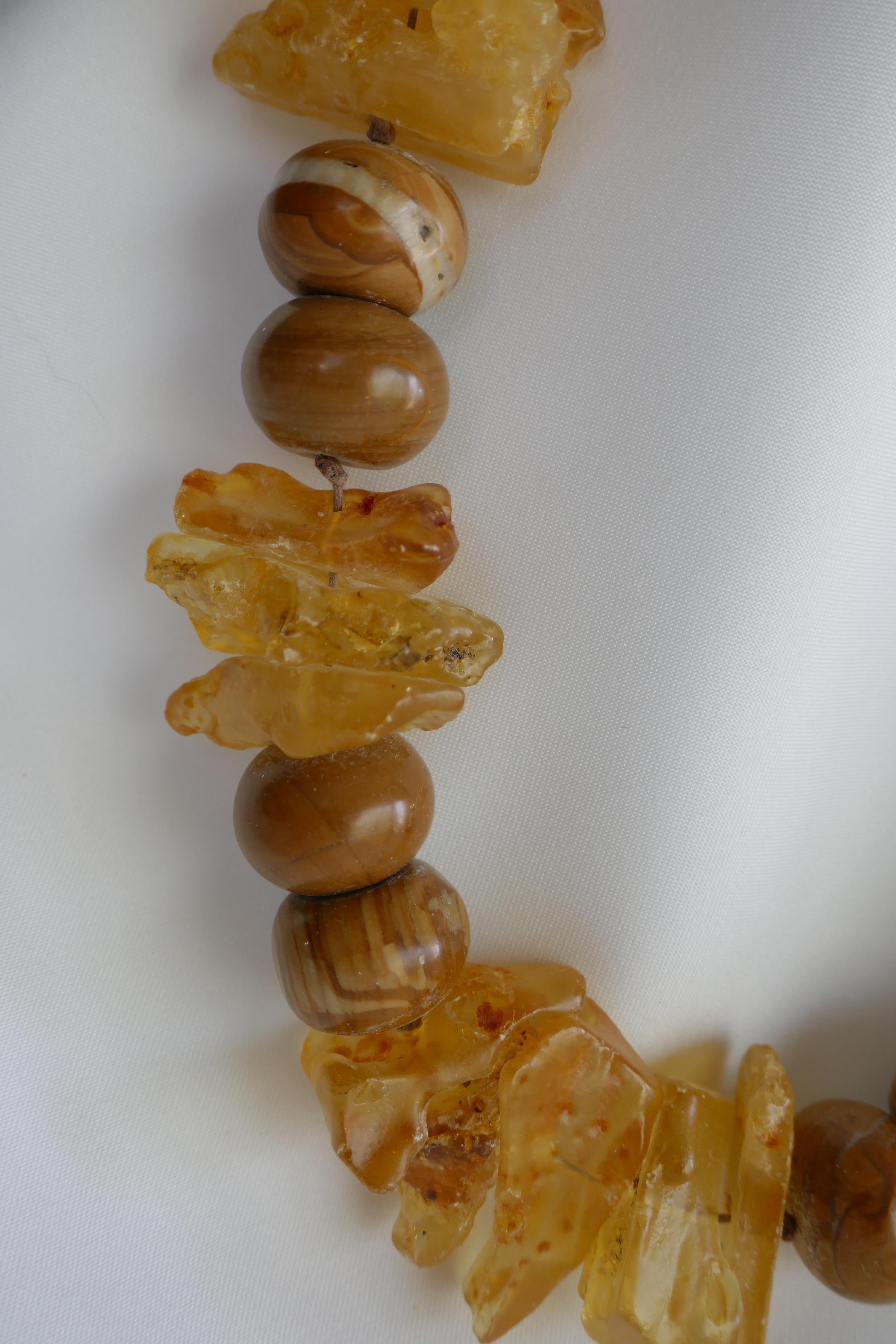 This necklace is definitely a statement piece which combines chunks of amber (yellow) and 20mm wood line jasper,  knotted on cotton cord. This necklace may be worn year round. It is a sculptural piece that looks amazing on and compliments many