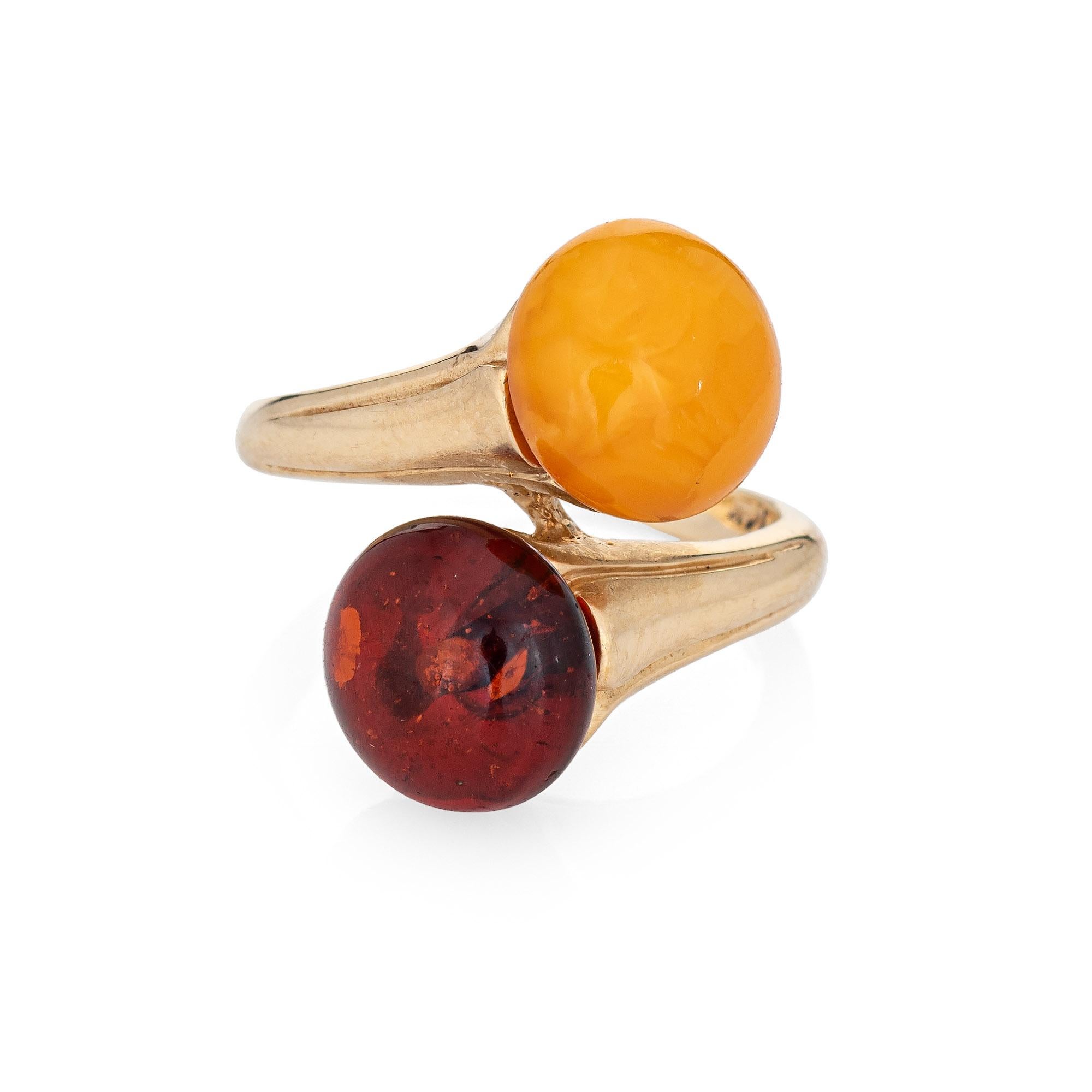 Finely detailed vintage amber 'toi et moi' ring crafted in 14k yellow gold. 

Two pieces of amber measure 9mm each. Note: slight chip to the yellow amber (visible under a 10x loupe). 

The two stone design or 