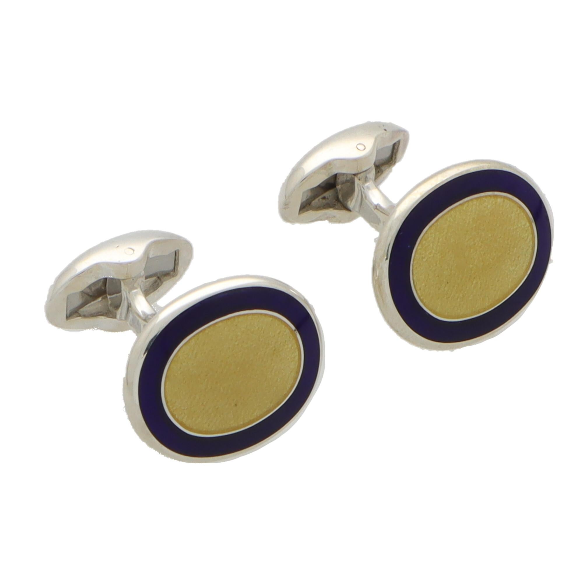 A stylish pair of navy and yellow enamel swivel back cufflinks made in British sterling silver.

Each cufflink is composed of two oval faces set centrally with a textured vibrant yellow panel and bordered by royal navy blue. They are secured to
