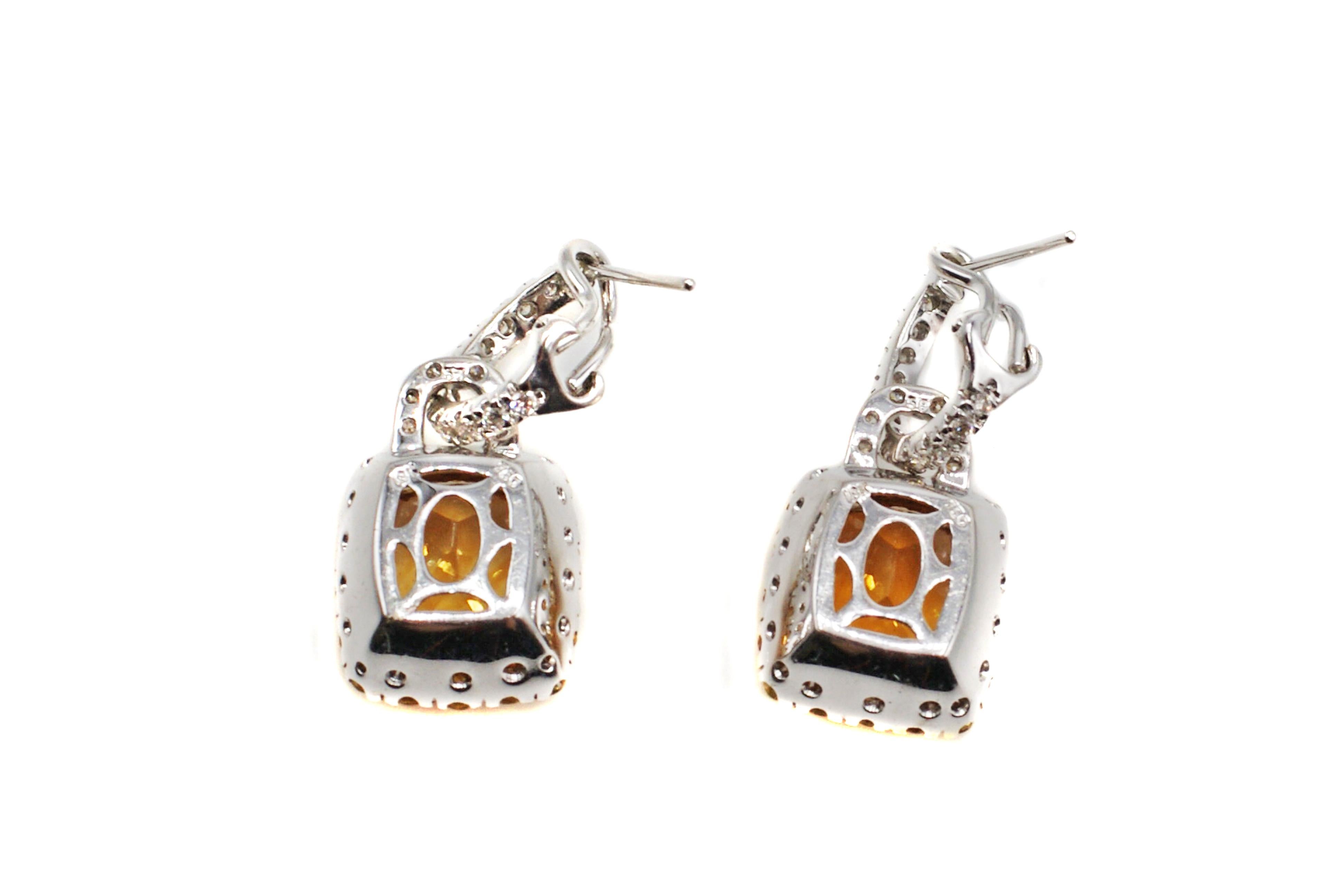 Beautifully designed and finely hand-crafted, these elegant ear pendants feature a pair of perfectly matched bright orange Citrines. The 2 cushion cut gems are measured to weigh approximately 5.5 carats, with a total weight of approximately 11