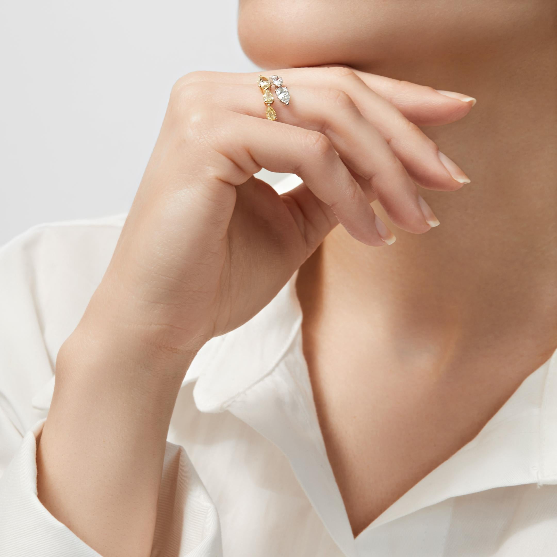Your perfect accessory awaits in the Yellow and White Diamond Bypass Ring. This chic statement piece embraces the finger with a line of pear-shaped white diamonds that faces a row of pear-shaped yellow diamonds. The ring’s open design is