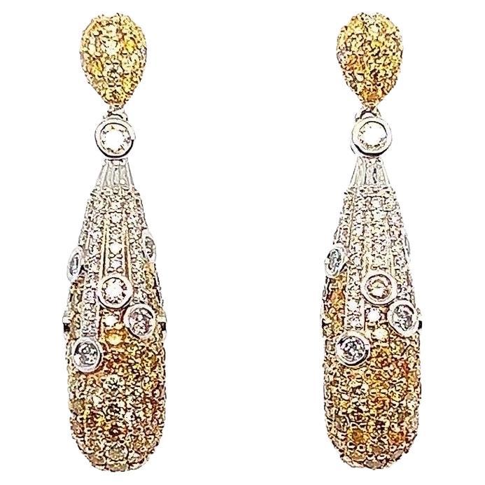 The design of these sparkling dangle earrings are known as “day and night”. What makes these earrings unique is how the diamonds transition from white to yellow. To give the earrings a “pop, bezel set diamonds are placed sparingly on the