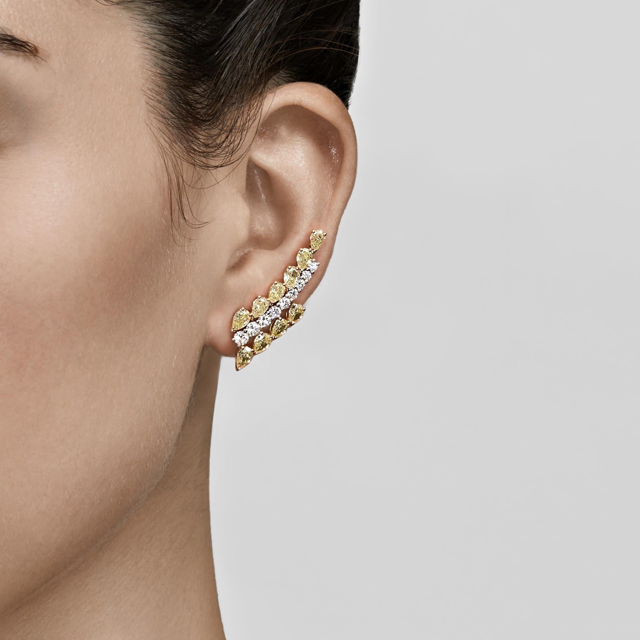 Ear climbers are so named because they are engineered like a traditional stud, but feature many stones that ascend the earlobe. This stunning pair of diamond ear climbers features a row of round brilliant-cut white diamonds set between two rows of