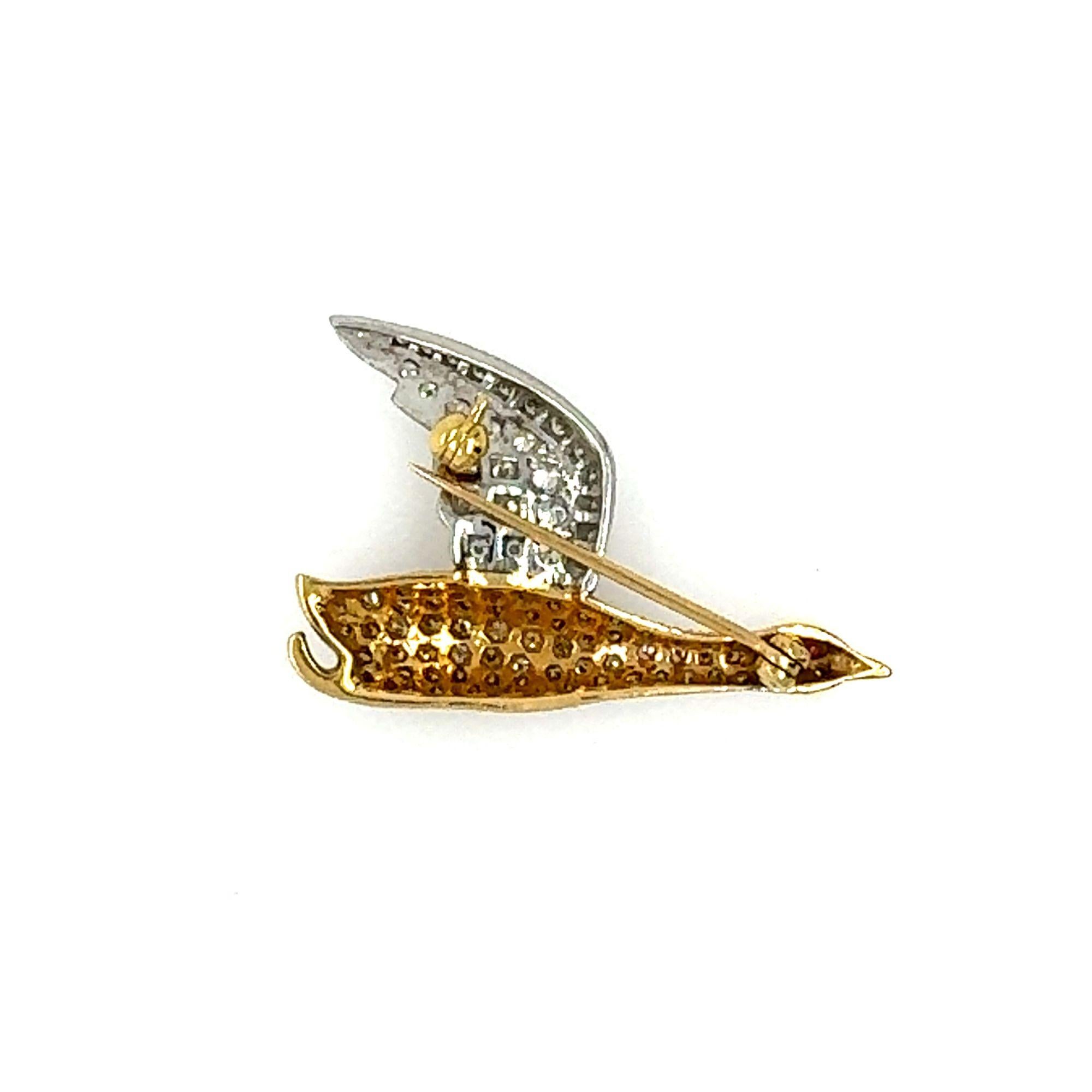 This exquisite flying duck brooch showcases a captivating design with natural fancy yellow diamonds adorning the body and sparkling white diamonds accentuating the wing. Crafted in 18 karat yellow and white gold, this charming piece features a ruby