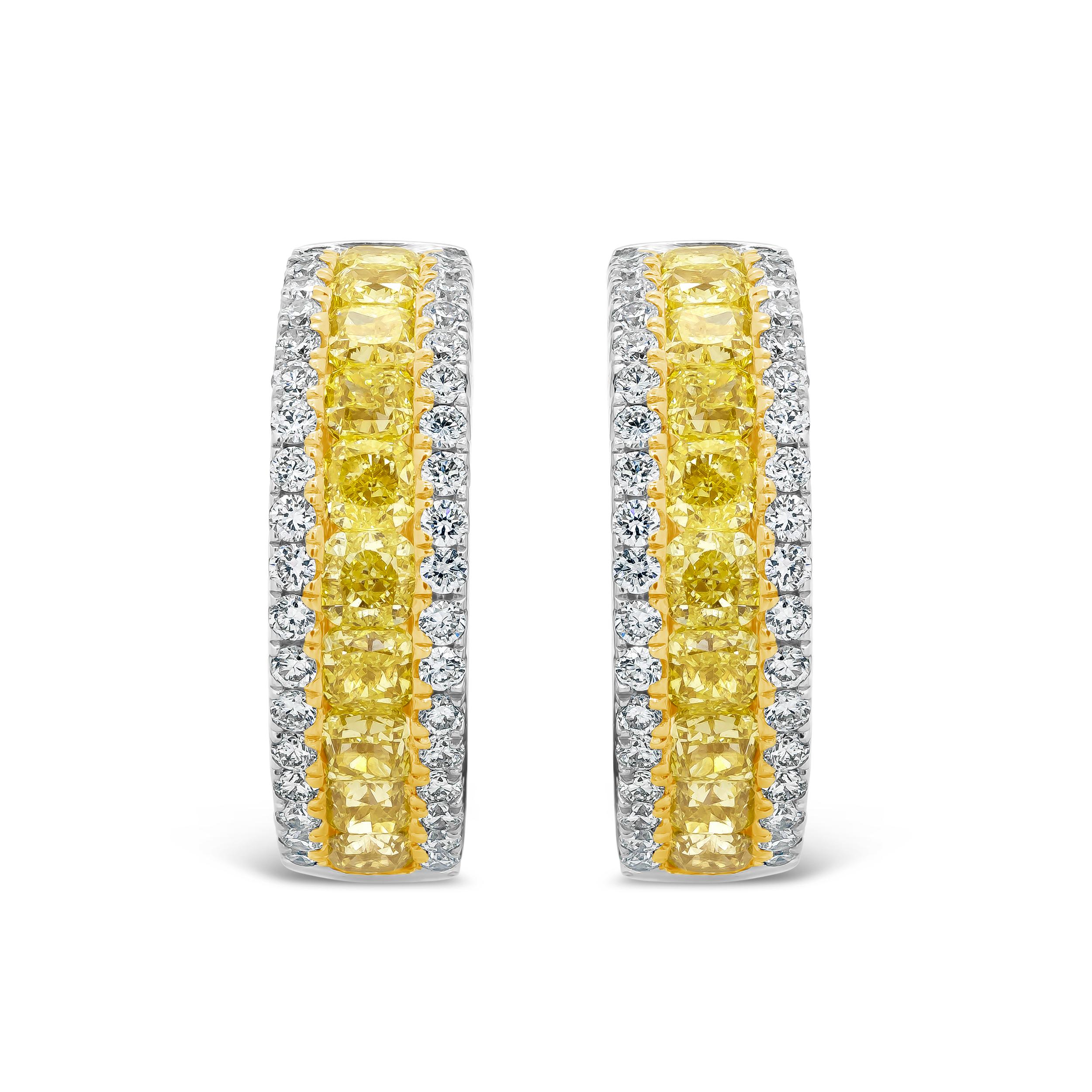 Each half-way hoop earring features a row of cushion cut yellow diamonds, channel set in a diamond encrusted white gold mounting. Yellow diamonds weigh 2.12 carats total; white diamonds weigh 0.63 carats total.

