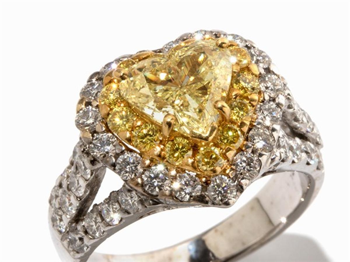 - Description de la
- Or blanc 750
- poinçonné au titre de la finesse
- 1 diamant jaune fantaisie de taille cœur, 1,42 ct, 
- 54 diamants blancs et jaunes, facettés, total 1,5 ct
- Taille de la bague : 53 ; US 6.4
- Poids : environ 7,8 g

Anneau de
