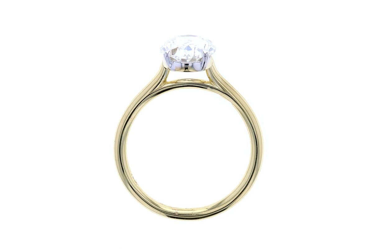 An elegant two tone yellow gold and white gold diamond engagement ring with an oval center. A built-in setting with eagle claw prongs makes for a dainty effect. With a yellow gold shank and a white gold head, this beautiful engagement ring is a