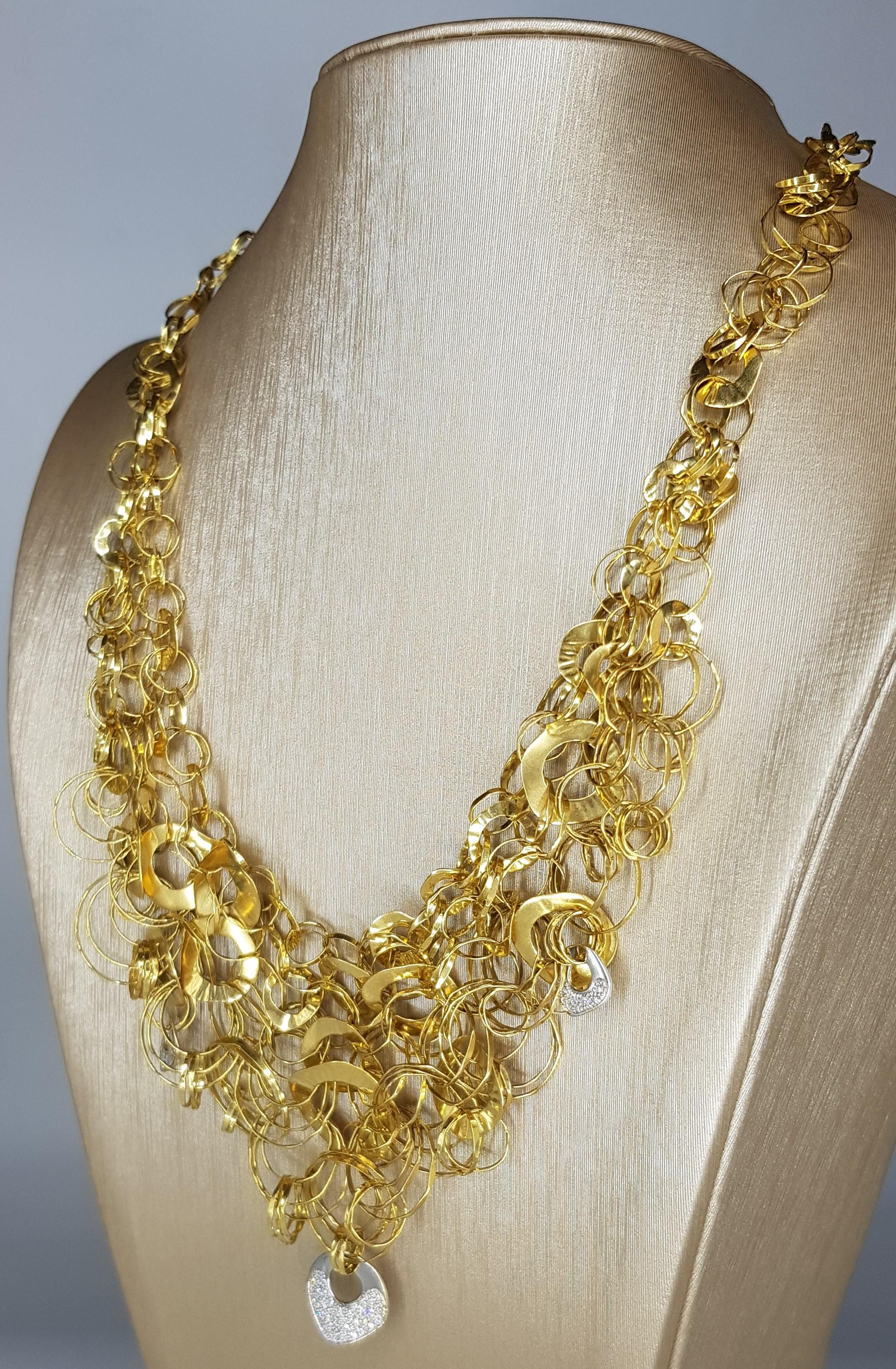 Orlandini 18k Yellow and White Gold with White Diamonds. The Necklace comprised of a plethora of interlocking hammered Yellow gold discs and rings with 3 White Gold discs and White Diamonds pavè (cts 0.73) 