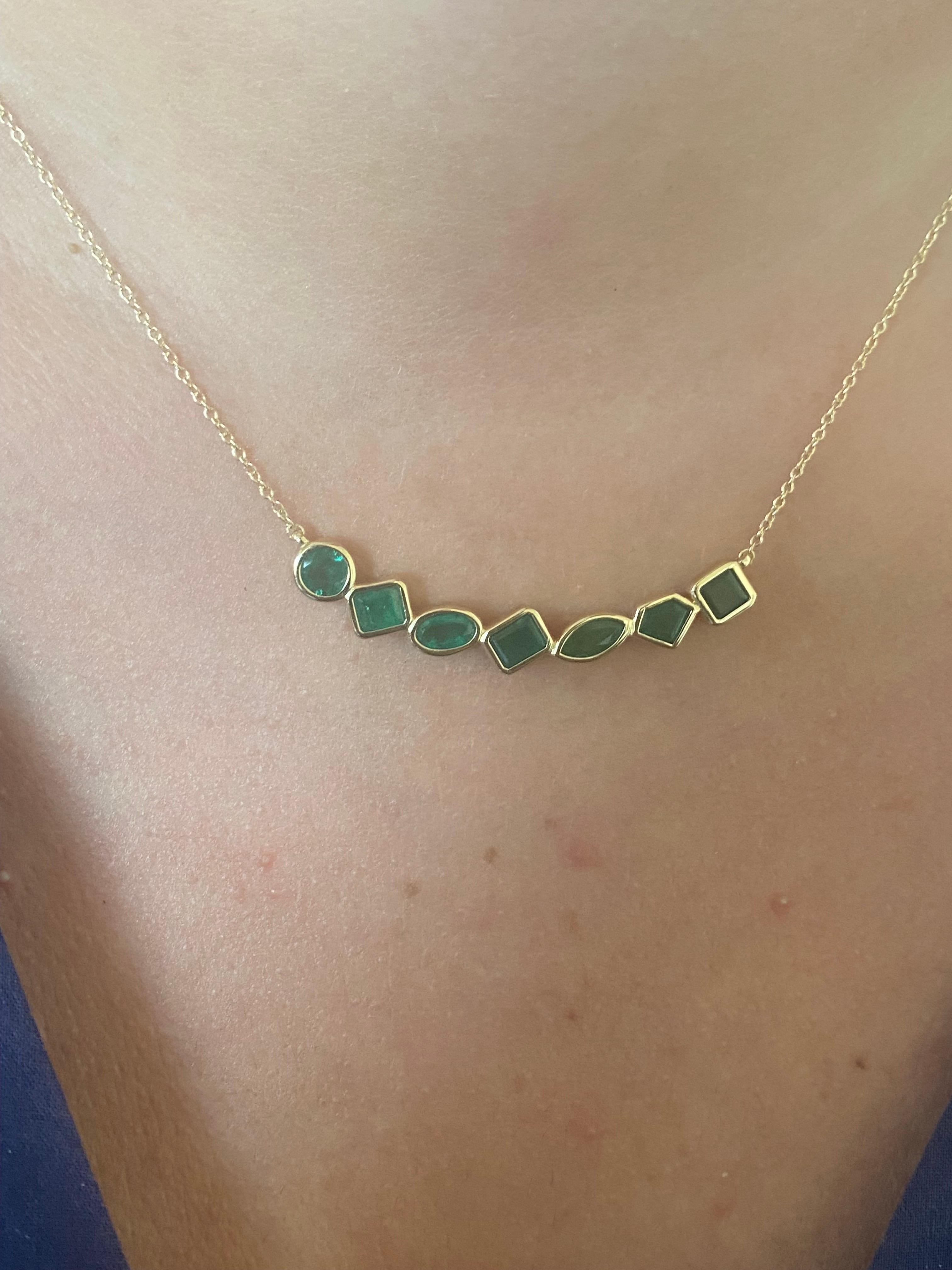 14K Gelb bar Anhänger abgestuft mit 7 grünen Smaragd Steine gesetzt. Die Steine bestehen aus Smaragden, runden, ovalen, prinzessinnen-, marquise- und trapezförmigen Steinen. Das Gesamtkaratgewicht beträgt 3,15 Karat.