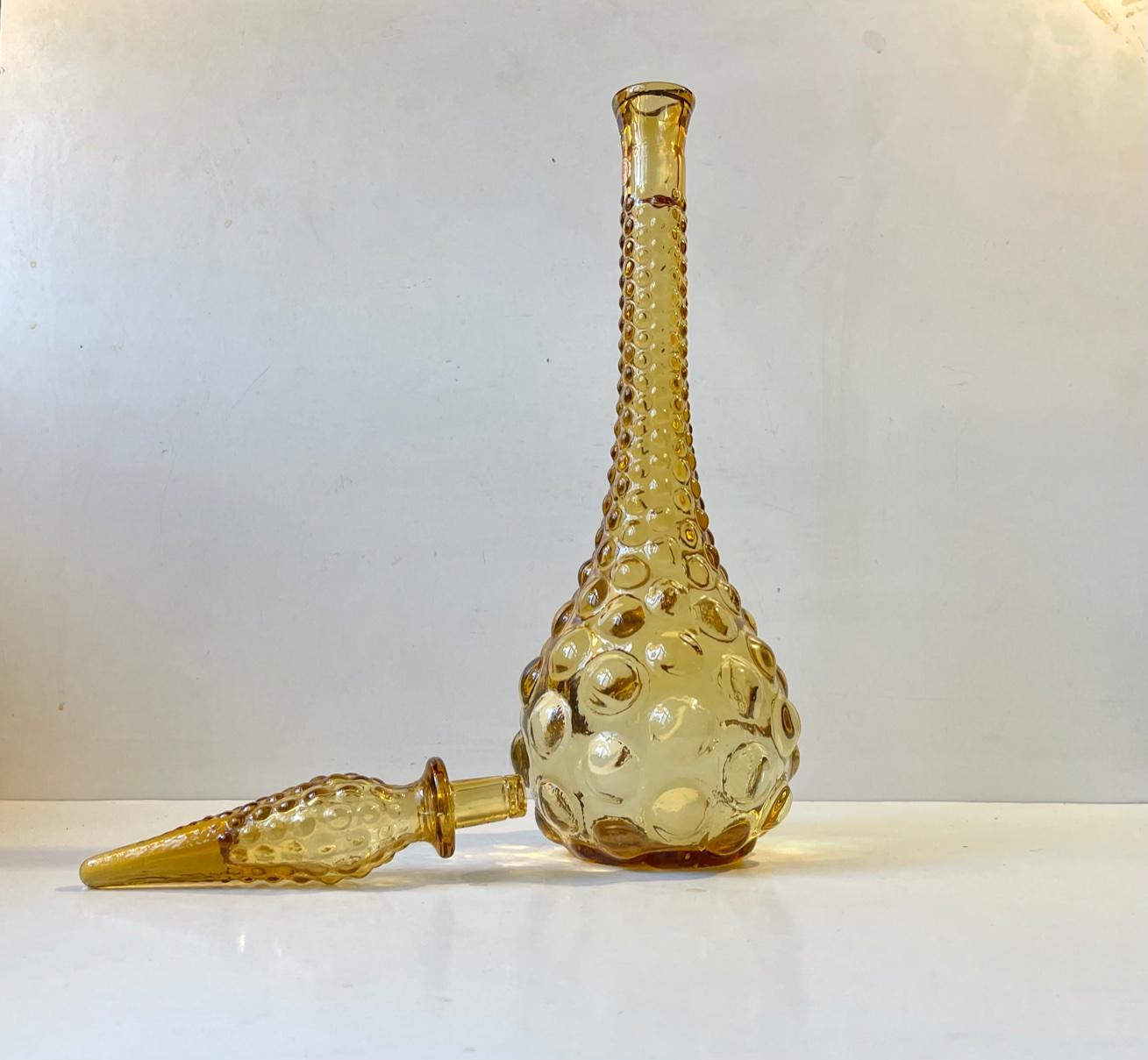 Ochre yellow glass decanter budding decor in relief. Designed and manufactured by Empoli in Italy during the early 1970s. This decorative decanter can contain between 1-1.5 liter spirits or water. Original made in Italy sticker from Empoli still