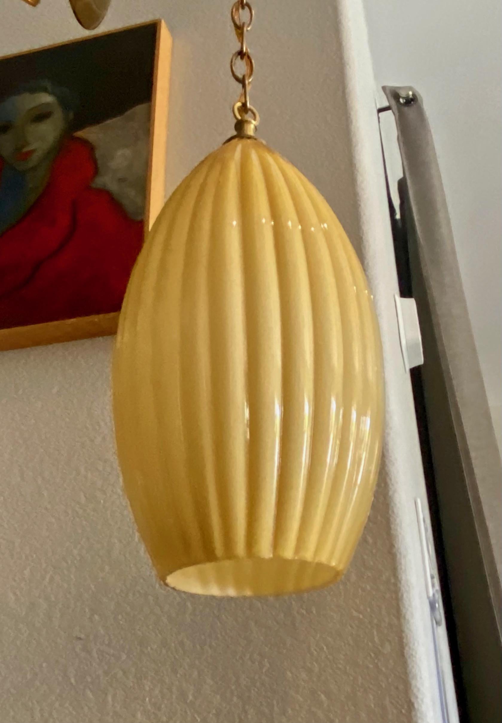 Single Murano Italian cased glass ribbed hanging ceiling pendant light, in a yellow butterscotch color. The glass gives a beautiful sunset yellow glow when lighted. Newly wired for US using single regular A base bulb. Incudes brass fittings, chain