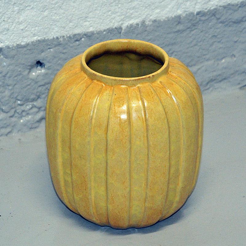 Vase en céramique jaune beige des années 1940, probablement produit par Upsala Ekeby, Suède. Le vase a une surface rifflée et rustique et une délicate forme ovale arrondie. Magnifique tel quel ou avec des fleurs. Bon état et design vintage. Mesures