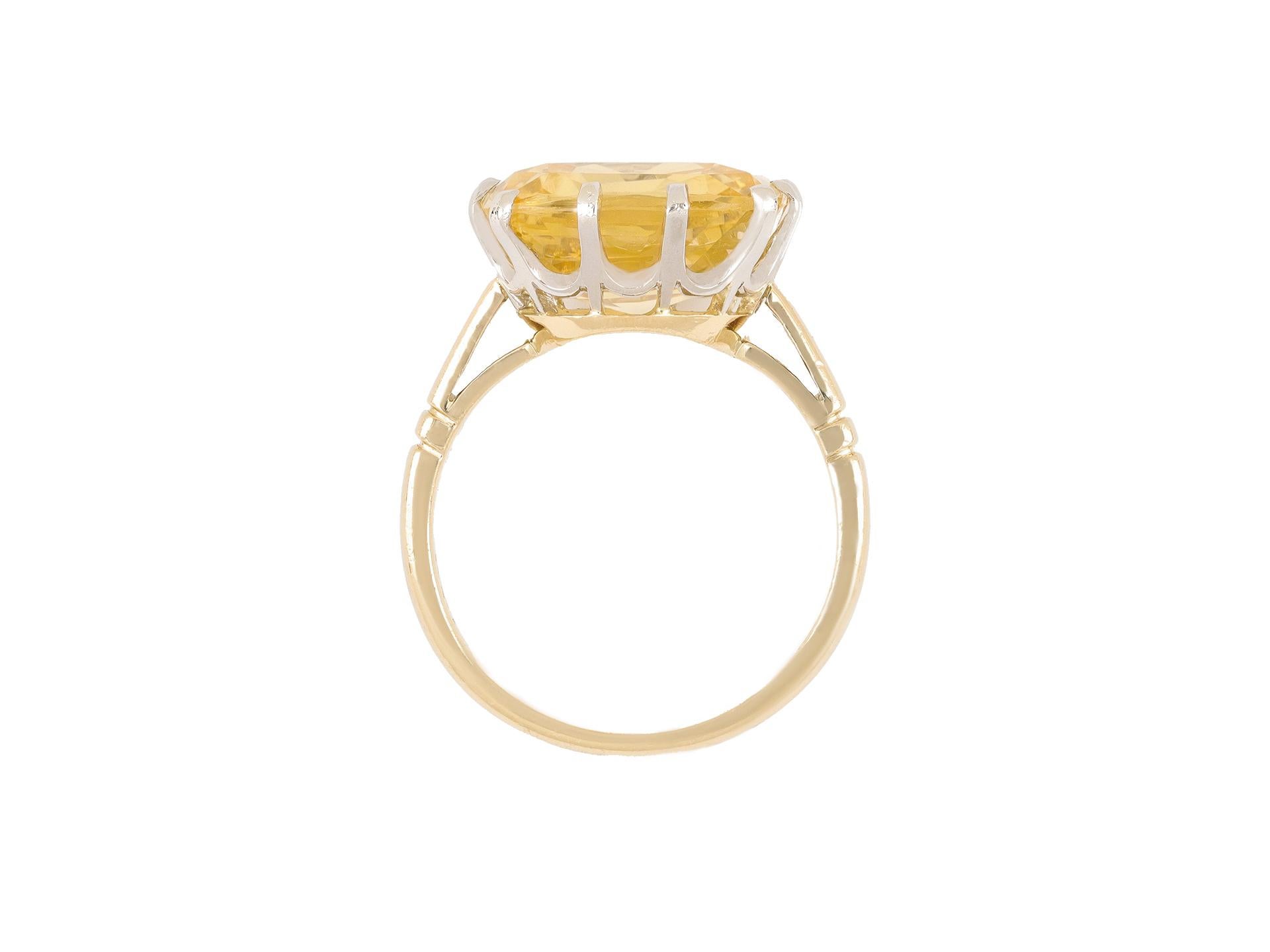 Yellow Ceylon sapphire solitaire ring. Set with a cushion cut natural unenhanced yellow Ceylon sapphire in an open back claw setting with an approximate weight of 13.30 carats, to an elegant solitaire design featuring curving claws, an intricate