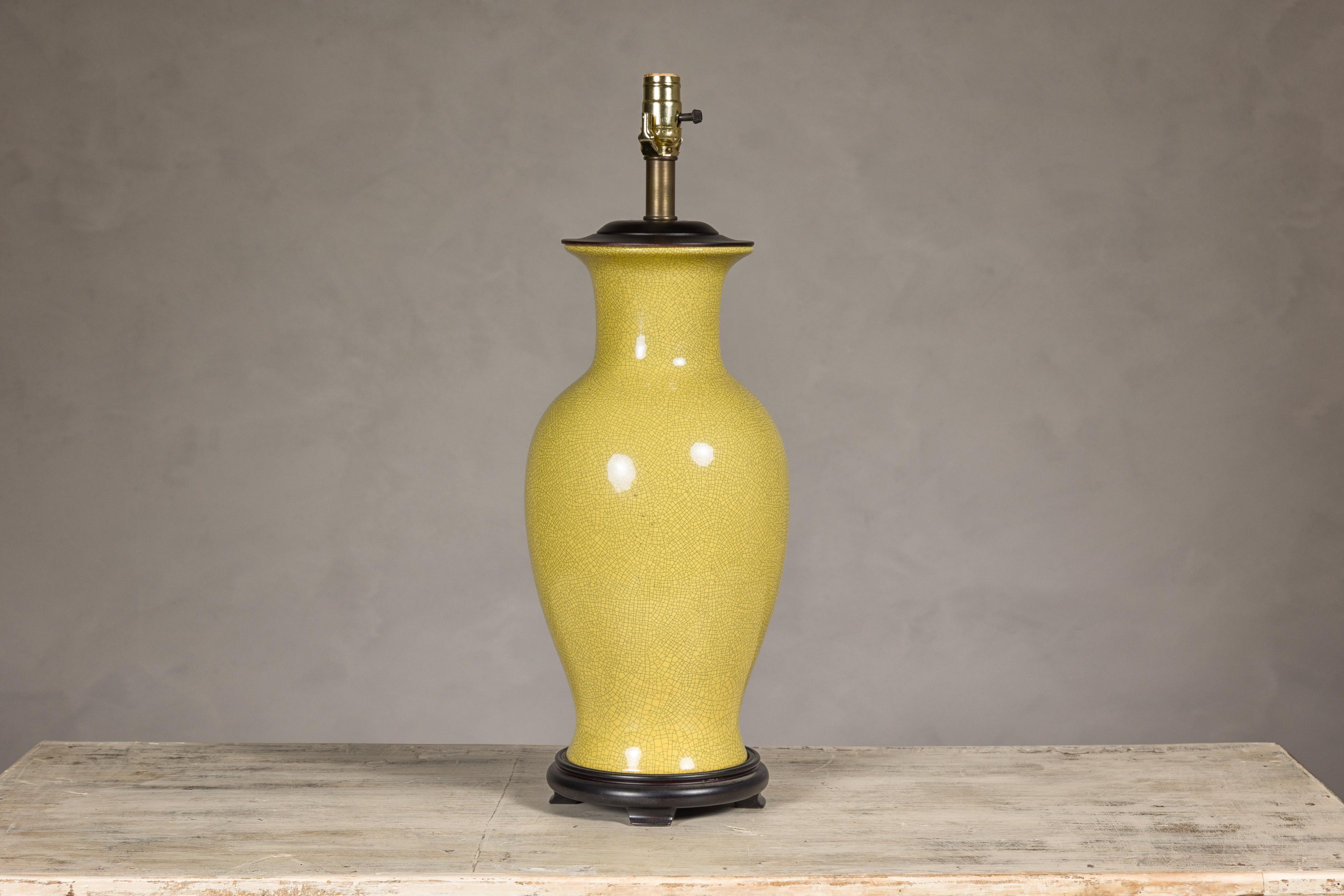 Eine Vintage-Altarvase mit gelbem Craquelé-Finish und ausladendem Hals, die auf einem runden Sockel zu einer für die USA verdrahteten Tischlampe gemacht wurde. Diese Vintage-Altarvase mit ihrem auffälligen gelben Craquelé-Finish wurde gekonnt in
