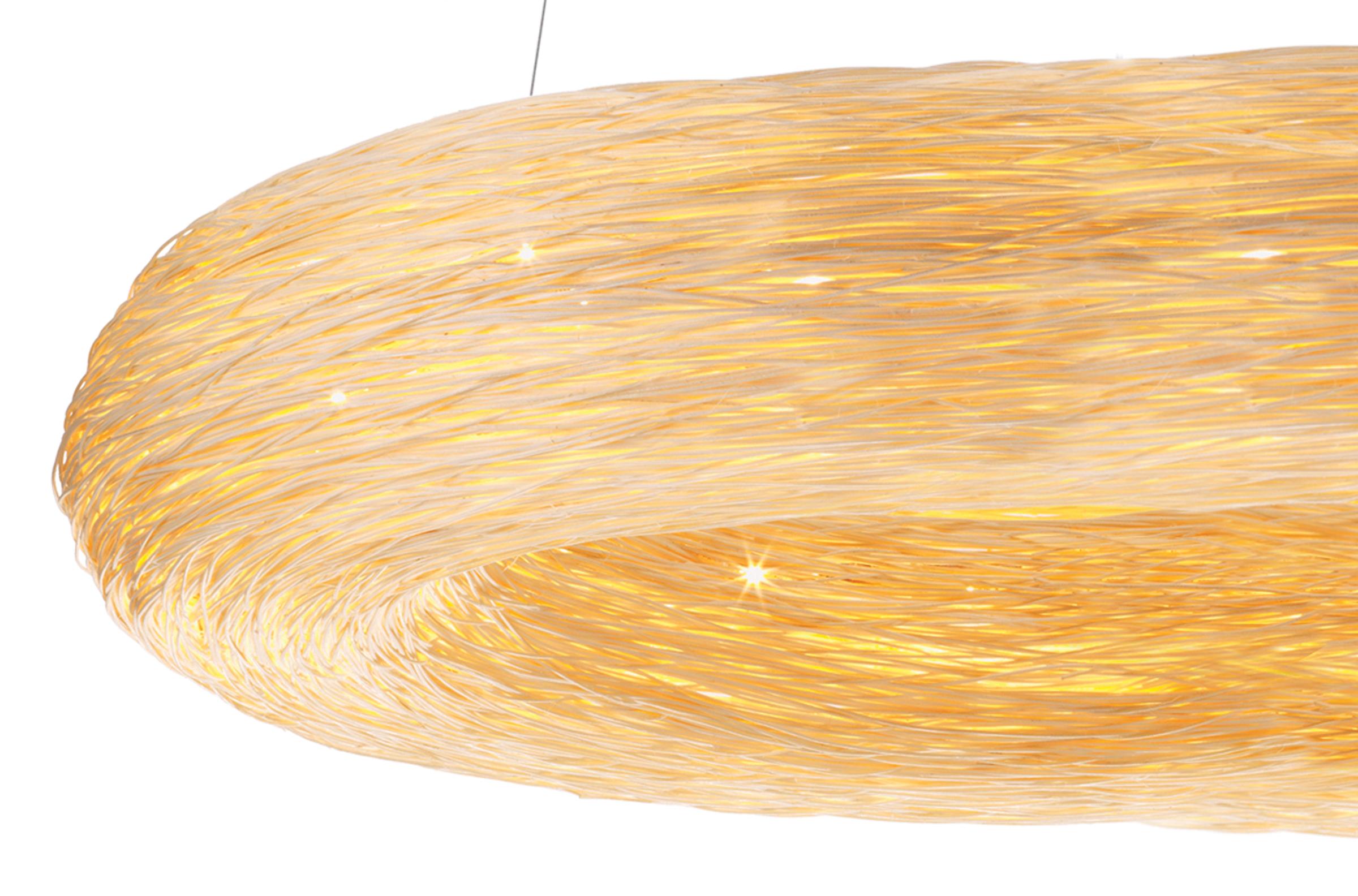 Yellow Crown 1100 est un anneau lumineux en rotin fabriqué à la main. Il fait partie d'une nouvelle génération d'éclairage conçue par Ango qui explore la magie des matériaux naturels combinés à la technologie des lampes LED. Le design reprend la