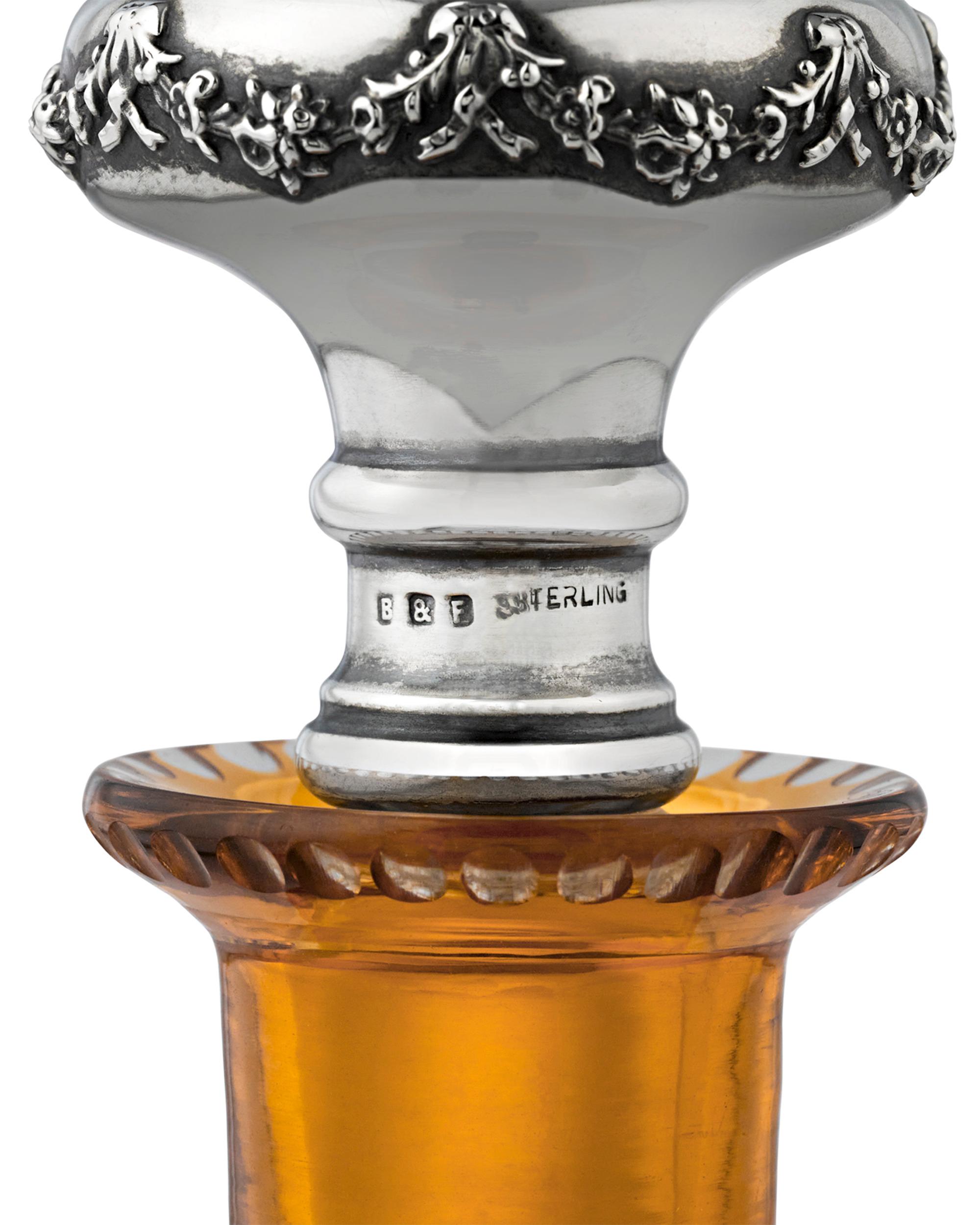 This incredibly rare and exquisitely lovely perfume bottle by celebrated English glassmakers Stevens & Williams features an elegant design on warm cut to clear yellow glass. The fluid curves of the bottle and repousséd sterling silver stopper