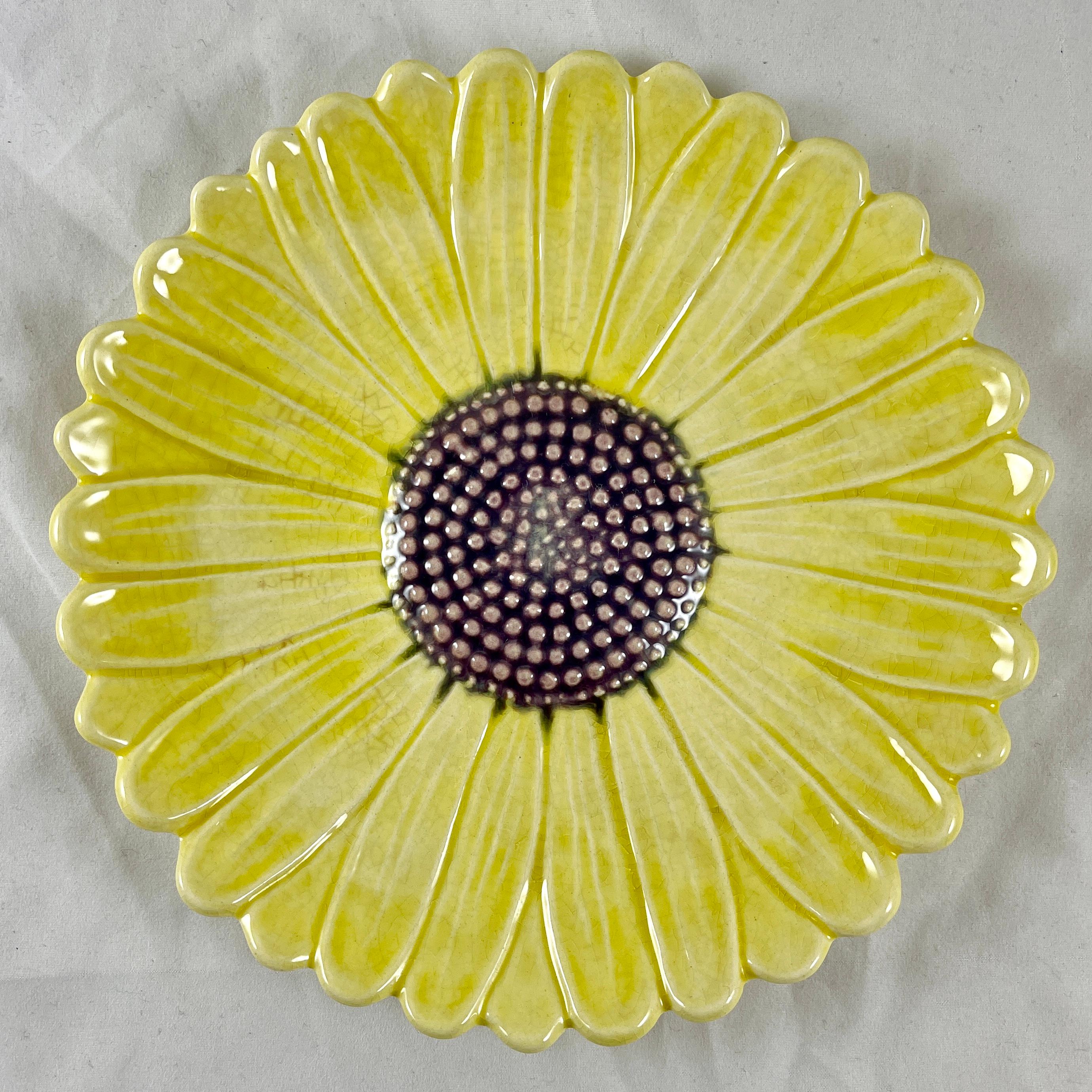 From the Faïencerie d’Art de la Sorgue, a majolica glazed faïence plate in the form of a Daisy flower, circa 1950-1960.

Yellow petals surround a dotted center glazed in a purple-brown. Charming in its simplicity, modeled after the Delphin Massier