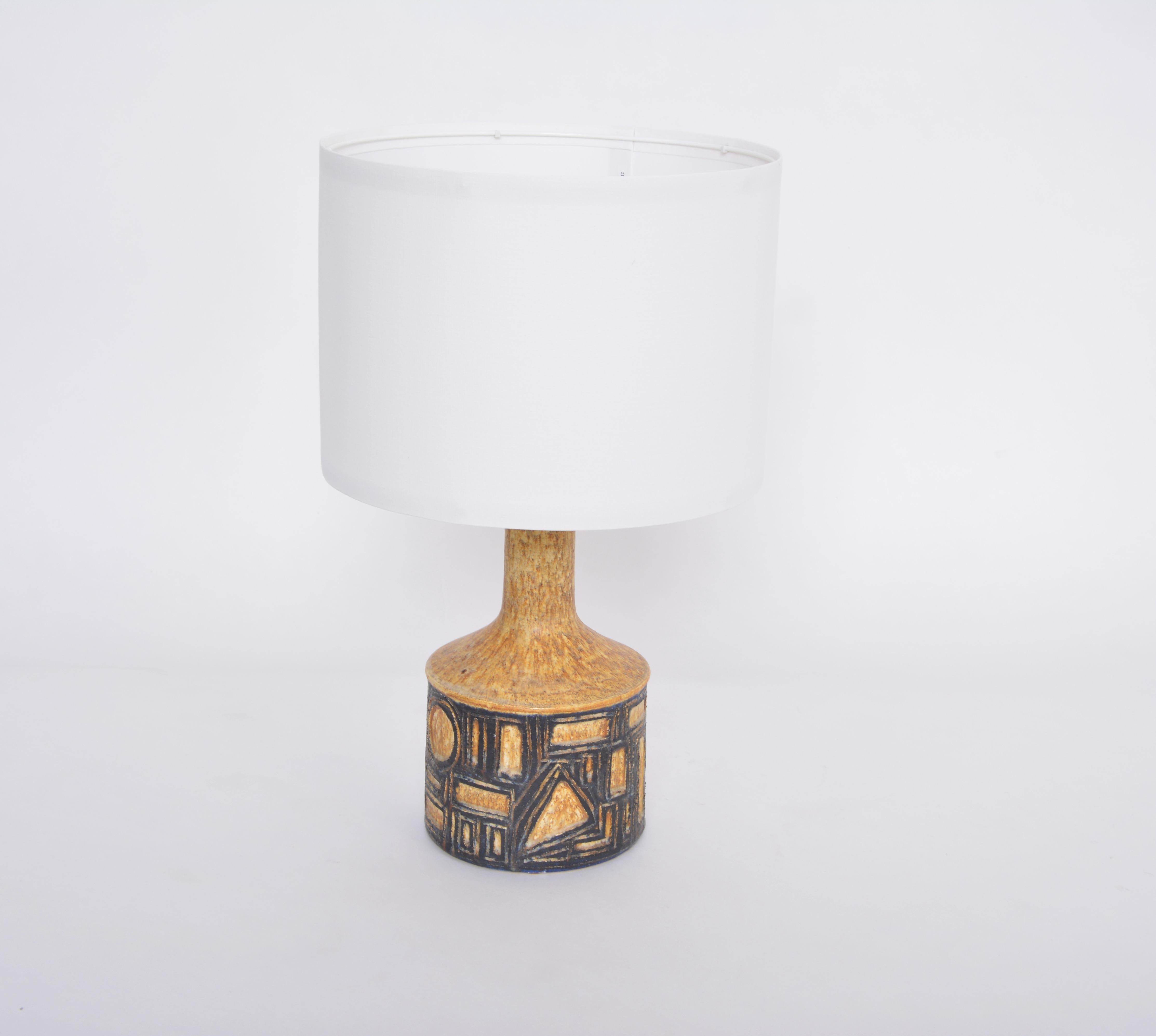 Unique table lamp handmade probably in the 1970s by artist Jette Hellerøe in Denmark. The lamp is made from yellow glazed stoneware and decorated with black abstract geometric figures and glazed in an expressive glossy glazing. The lamp is a