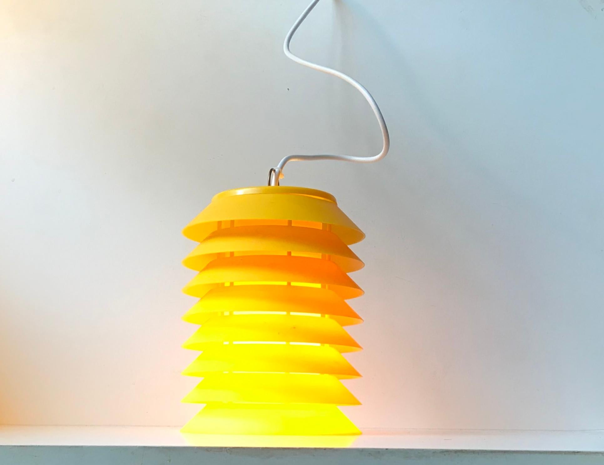 Bright yellow eight-tiered pendant lamp composed of plastic and a white light reflective acrylic tubular inner shade. The light features its original brass and resin socket. It was manufactured by Høyrup Lights in Denmark during the 1970s. This