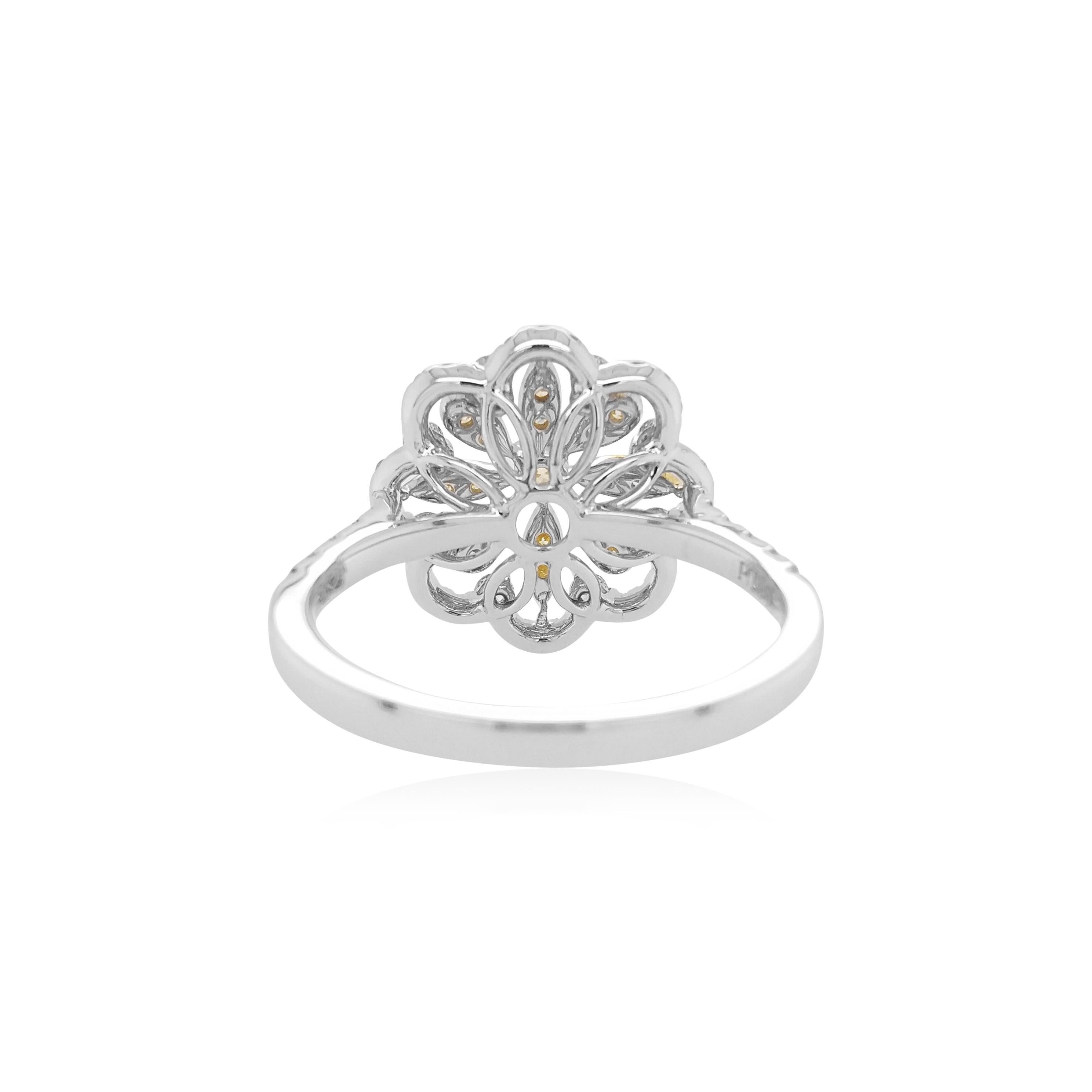 This unique flower shaped ring features natural Yellow diamonds at the heart of the design. The rich colour of these diamonds is complimented perfectly by the delicate platinum floral design which completed by a combination of round brilliant-cut